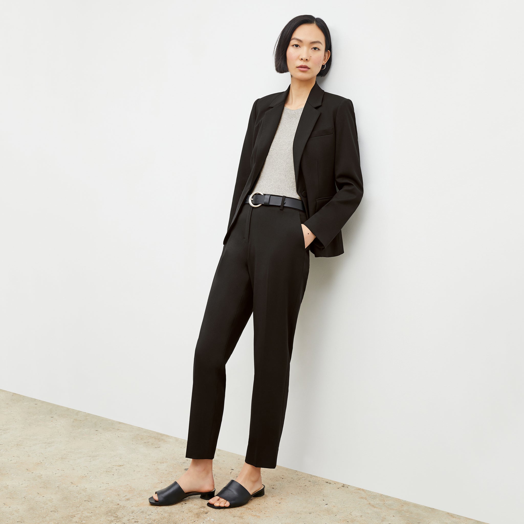 Front image of a woman standing wearing the Mejia pant in black