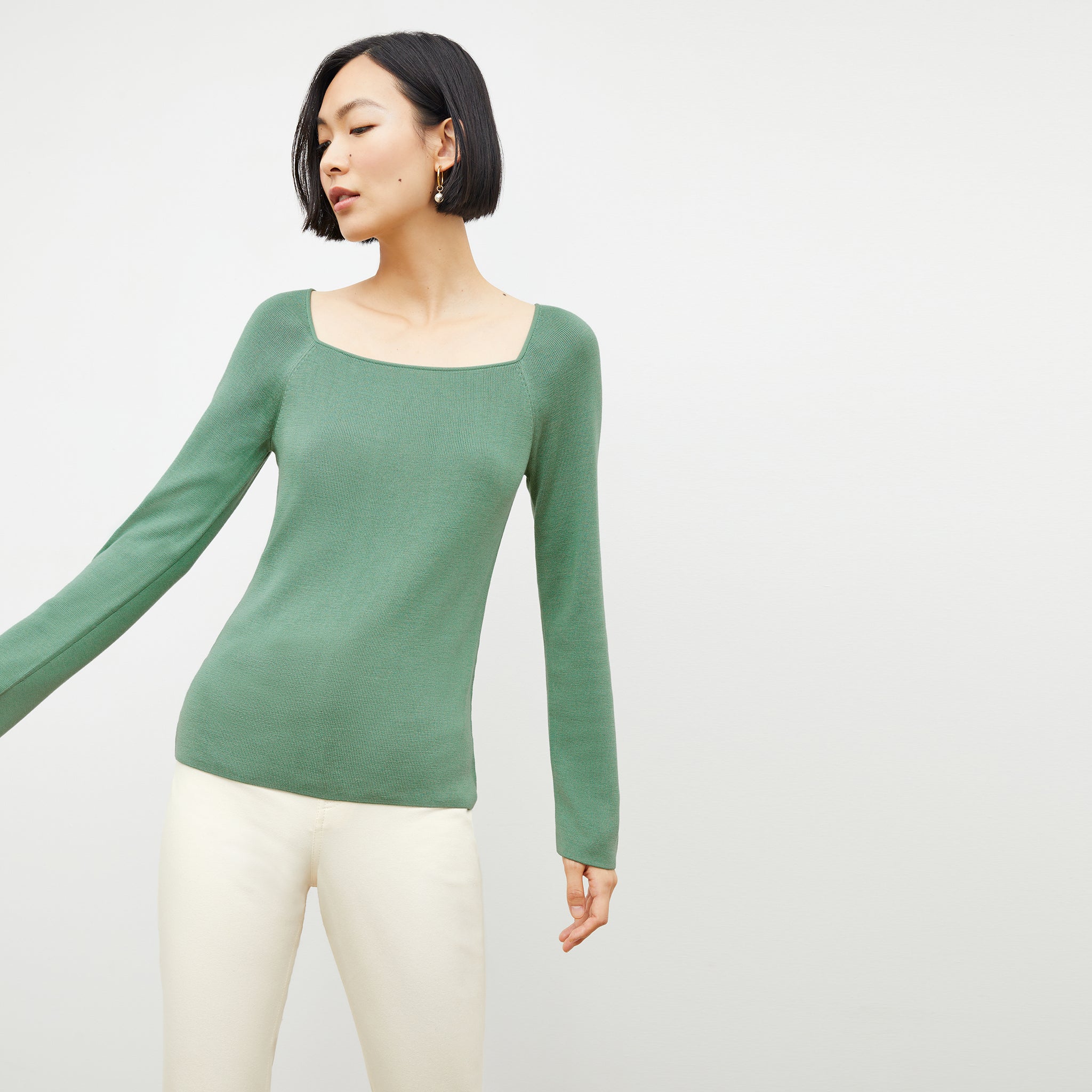 Front image of a woman wearing the joya top in spring green