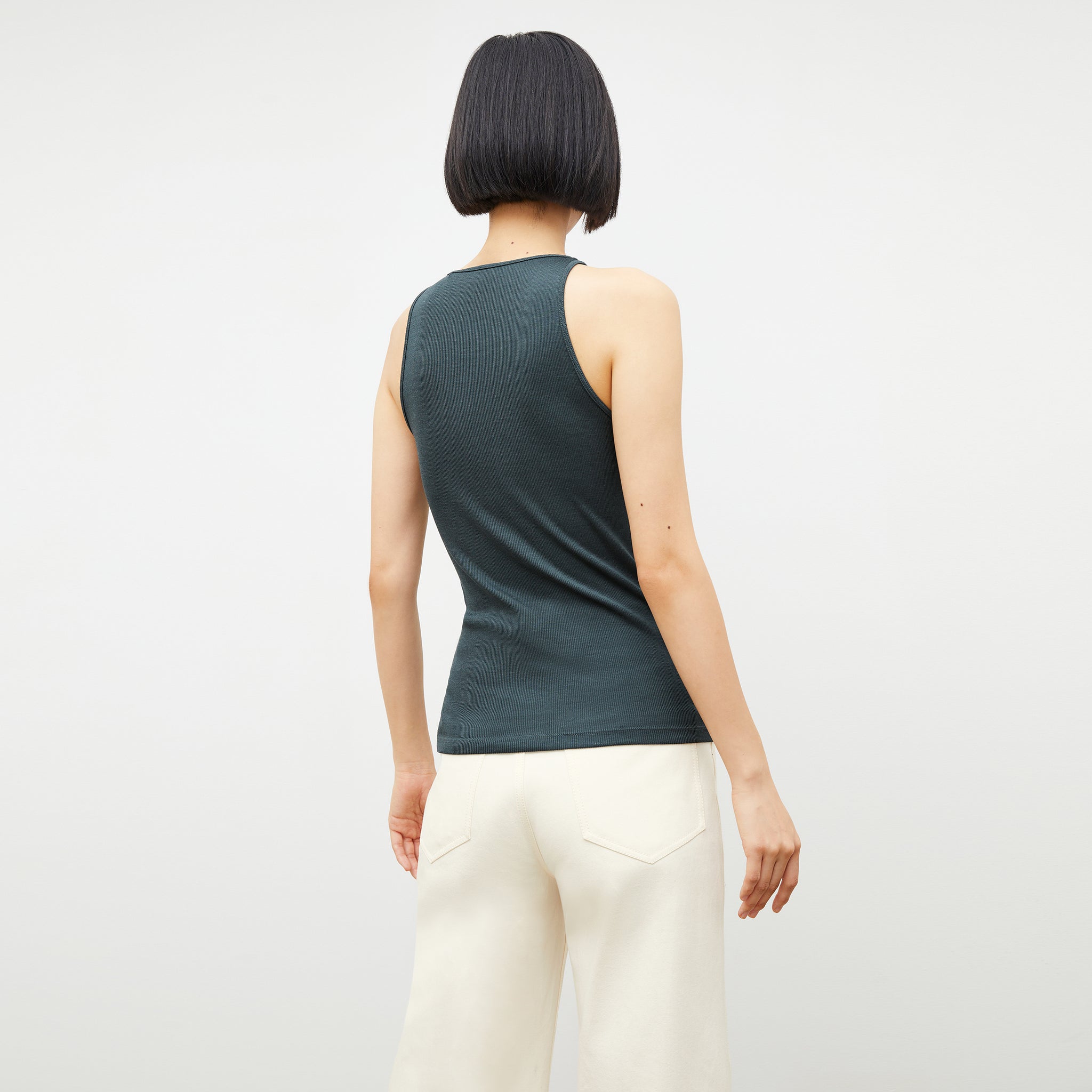 Back image of a woman wearing the aubry tank in deep sea