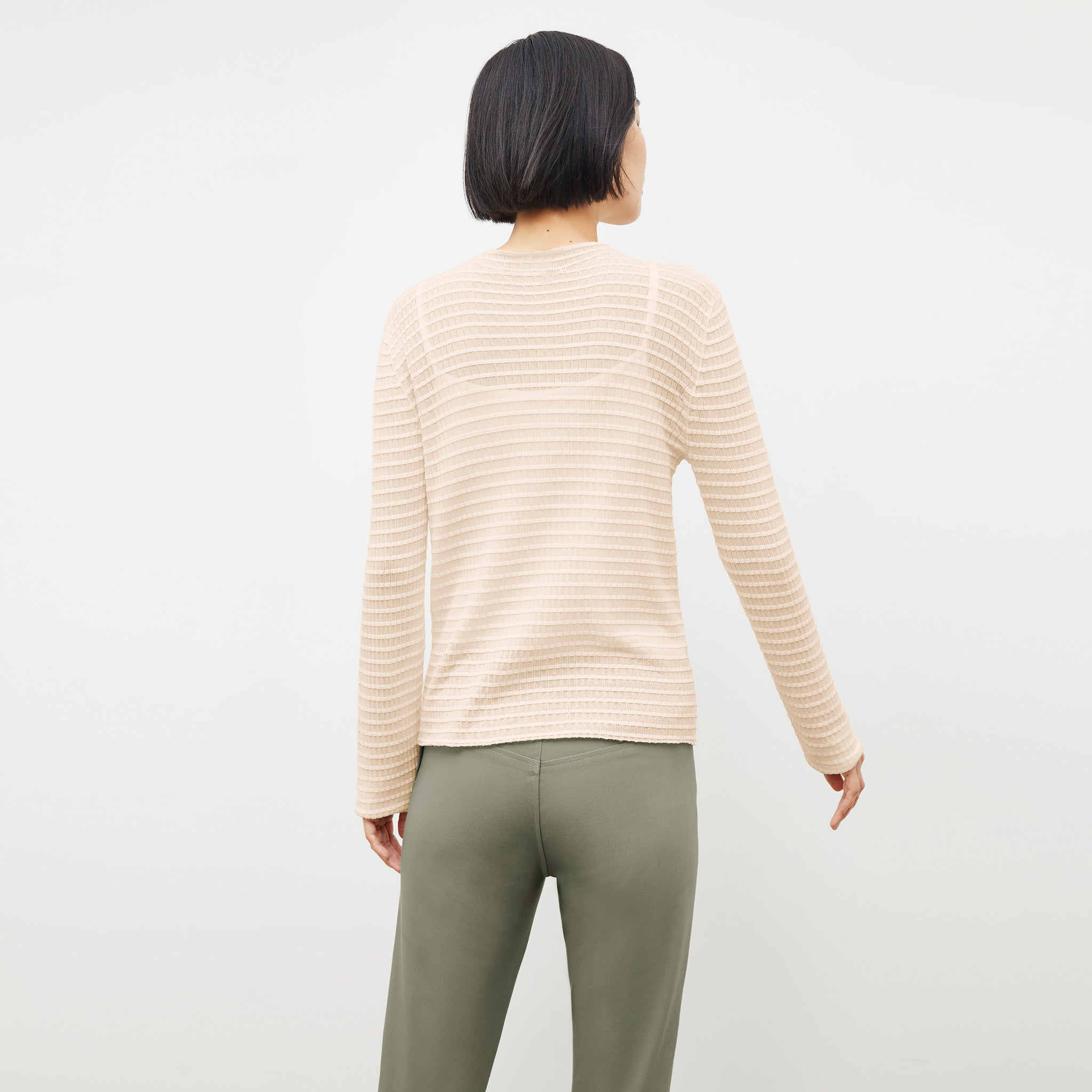 Back image of a woman standing wearing the Emerson Cardigan in Meringue