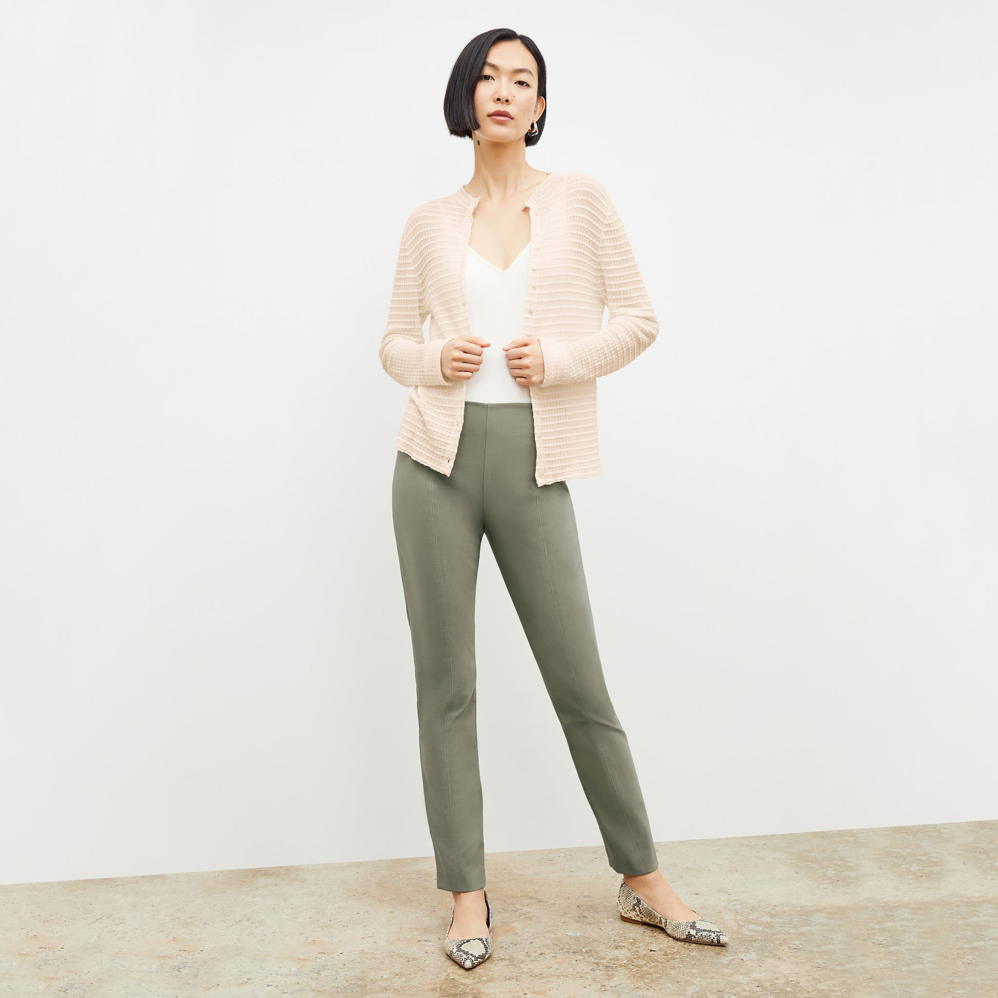 Front image of a woman standing wearing the Emerson Cardigan in Meringue 