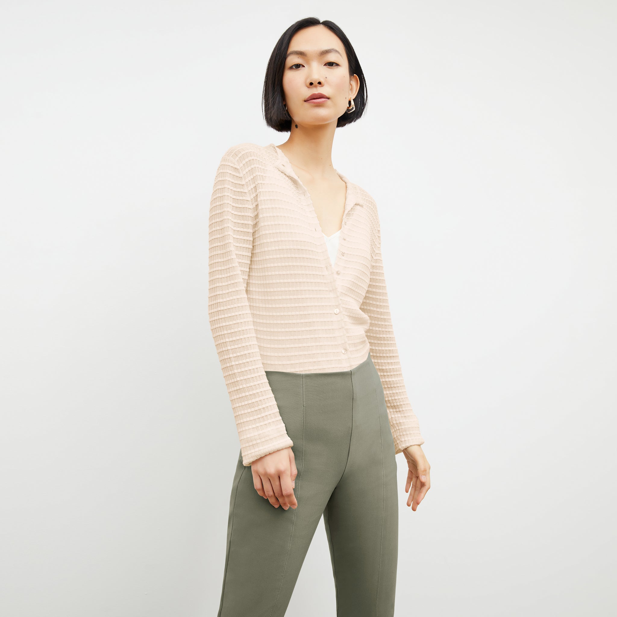Front image of a woman standing wearing the Emerson Cardigan in Meringue