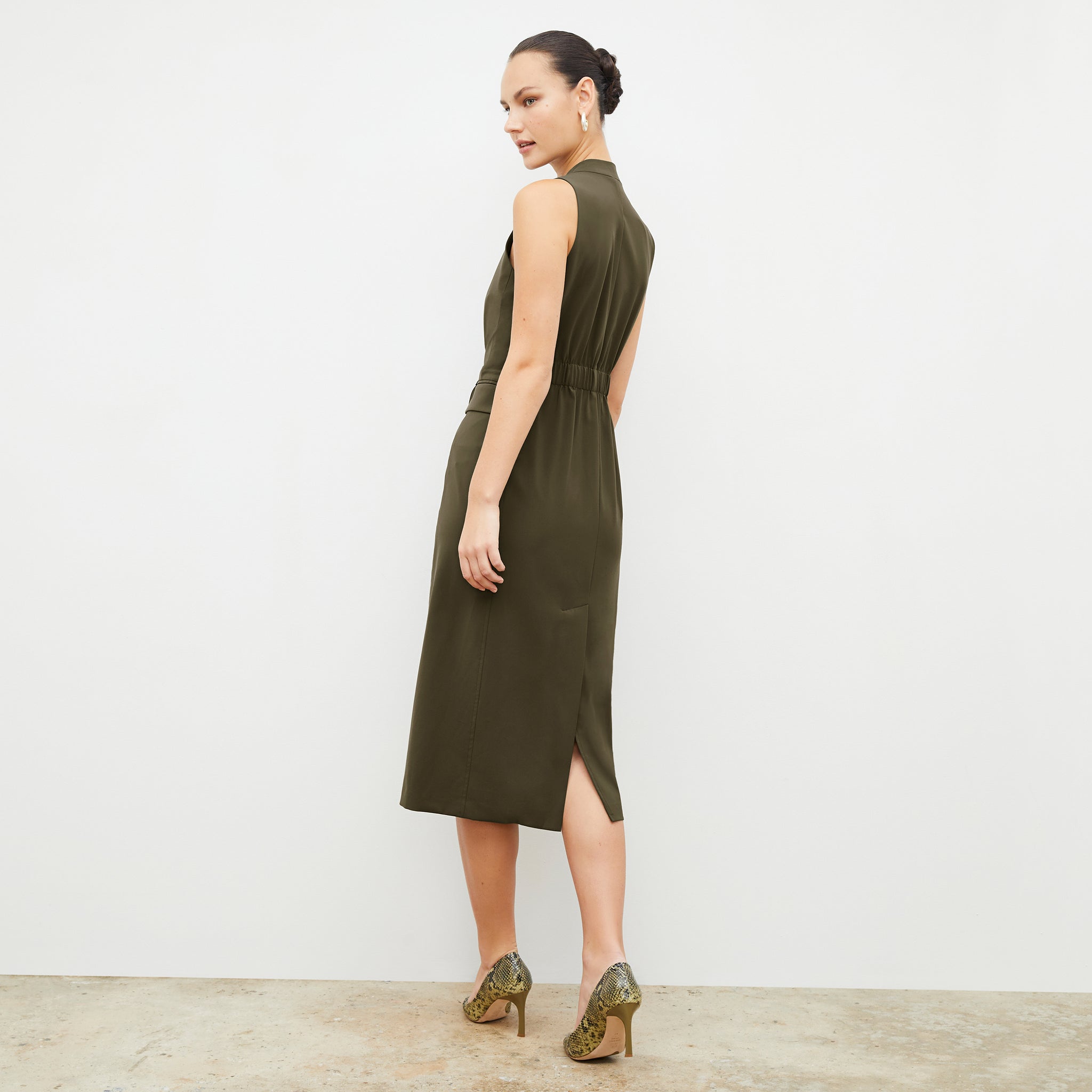 Back image of a woman wearing the Cassandra dress in origamitech in olive 