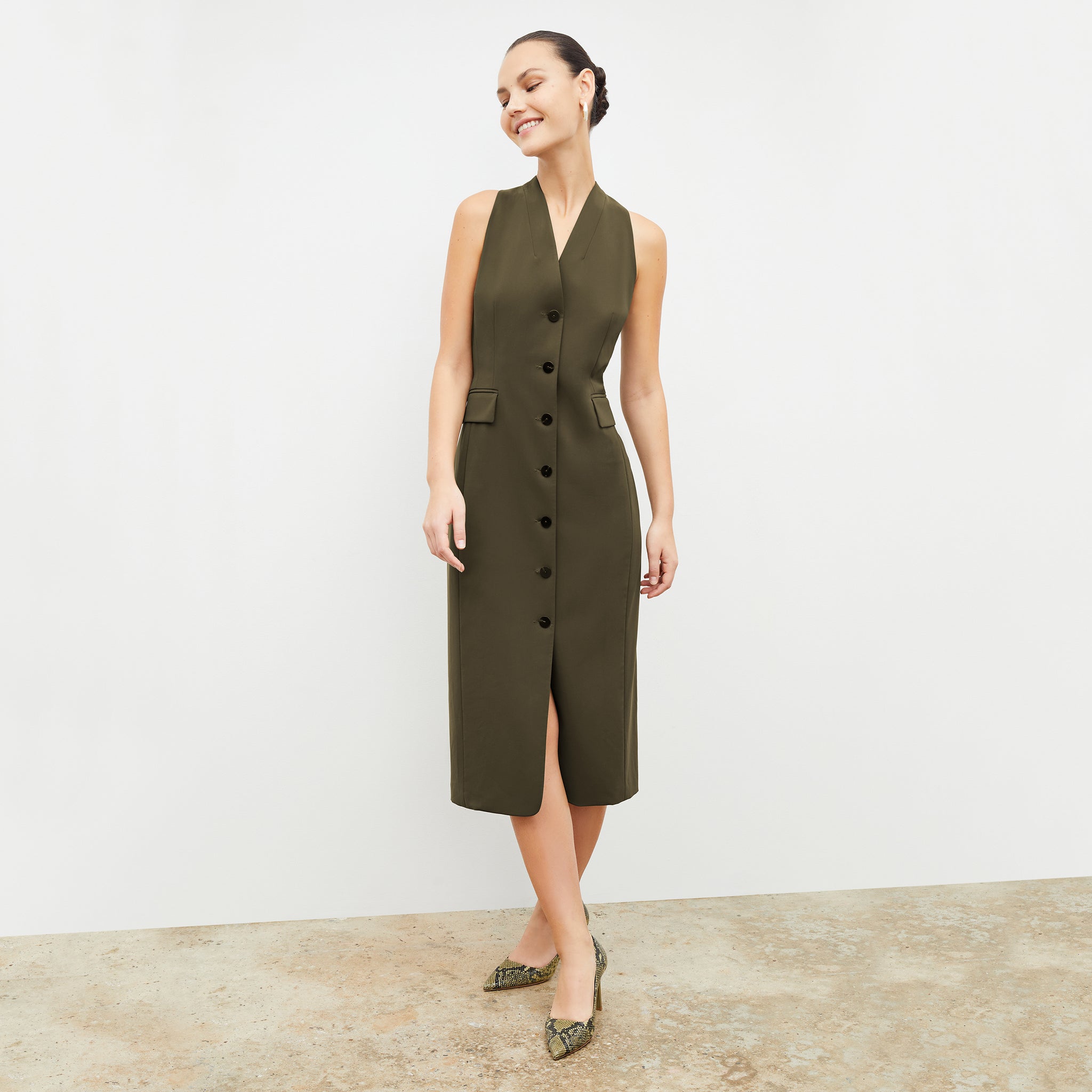Front image of a woman wearing the Cassandra dress in origamitech in olive 