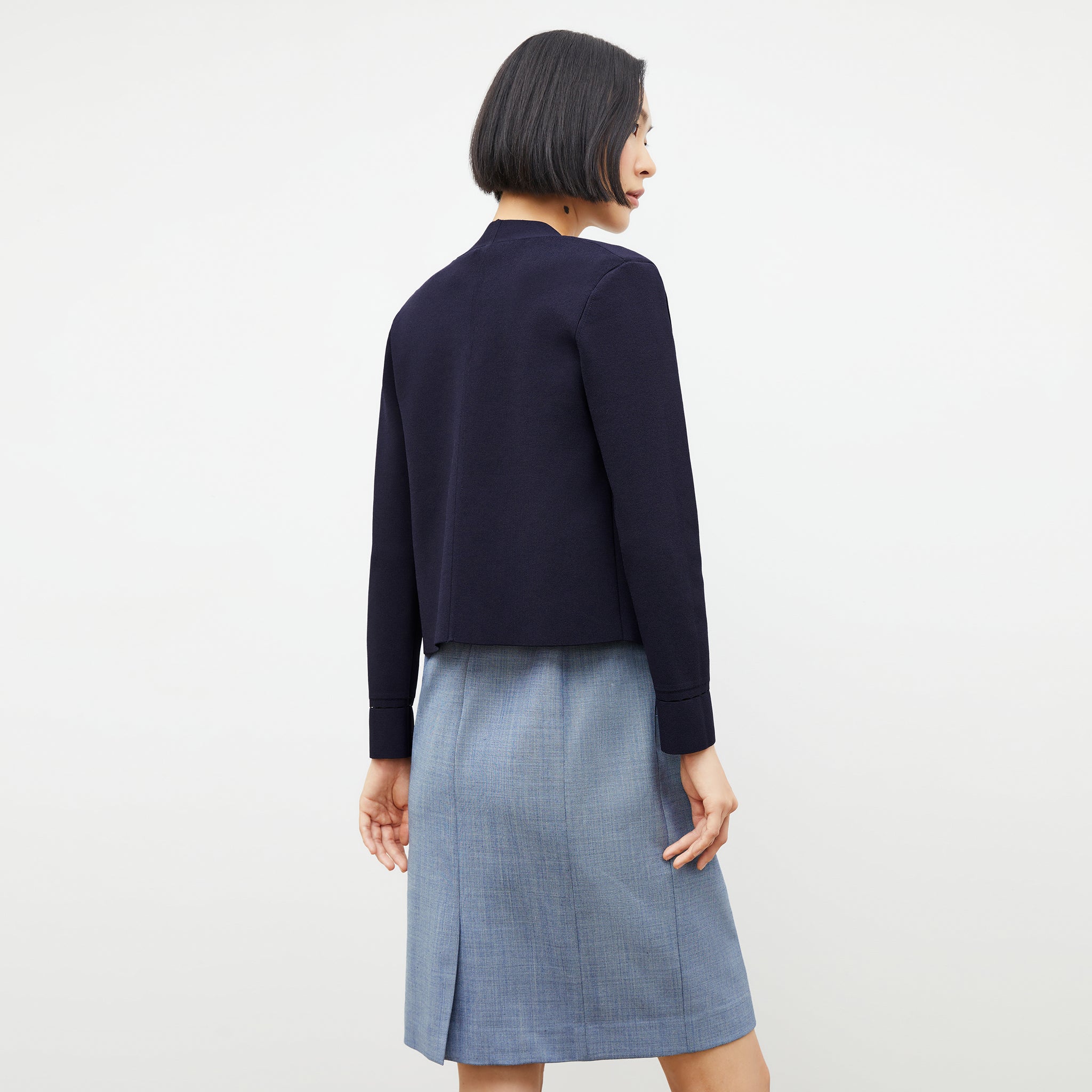 back image of a woman wearing the sant ambroeus jardigan in navy