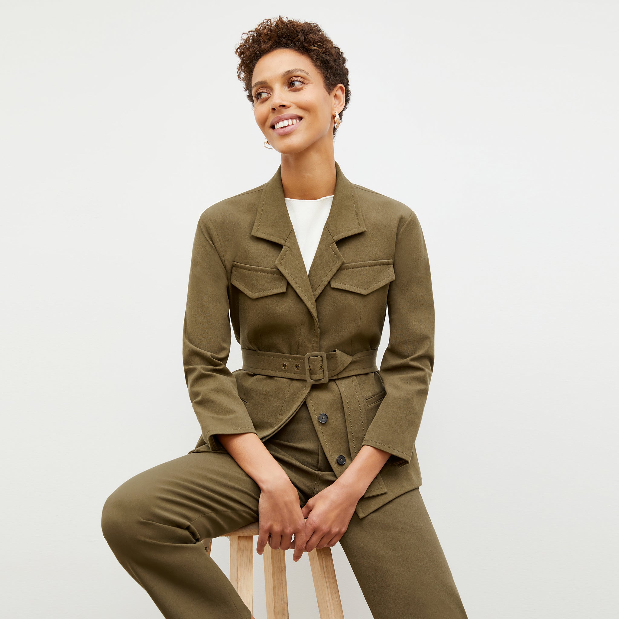 Front image of a woman sitting wearing the Eileen Top in ivory