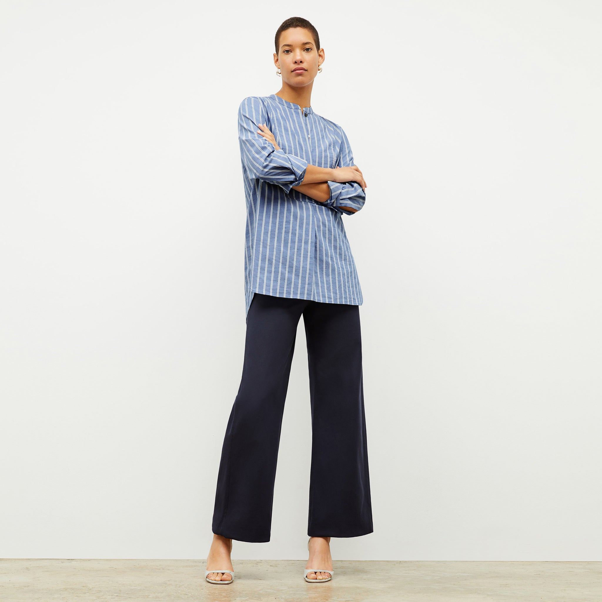 front image of a woman wearing the Nichols shirt in blue and white poplin stripe