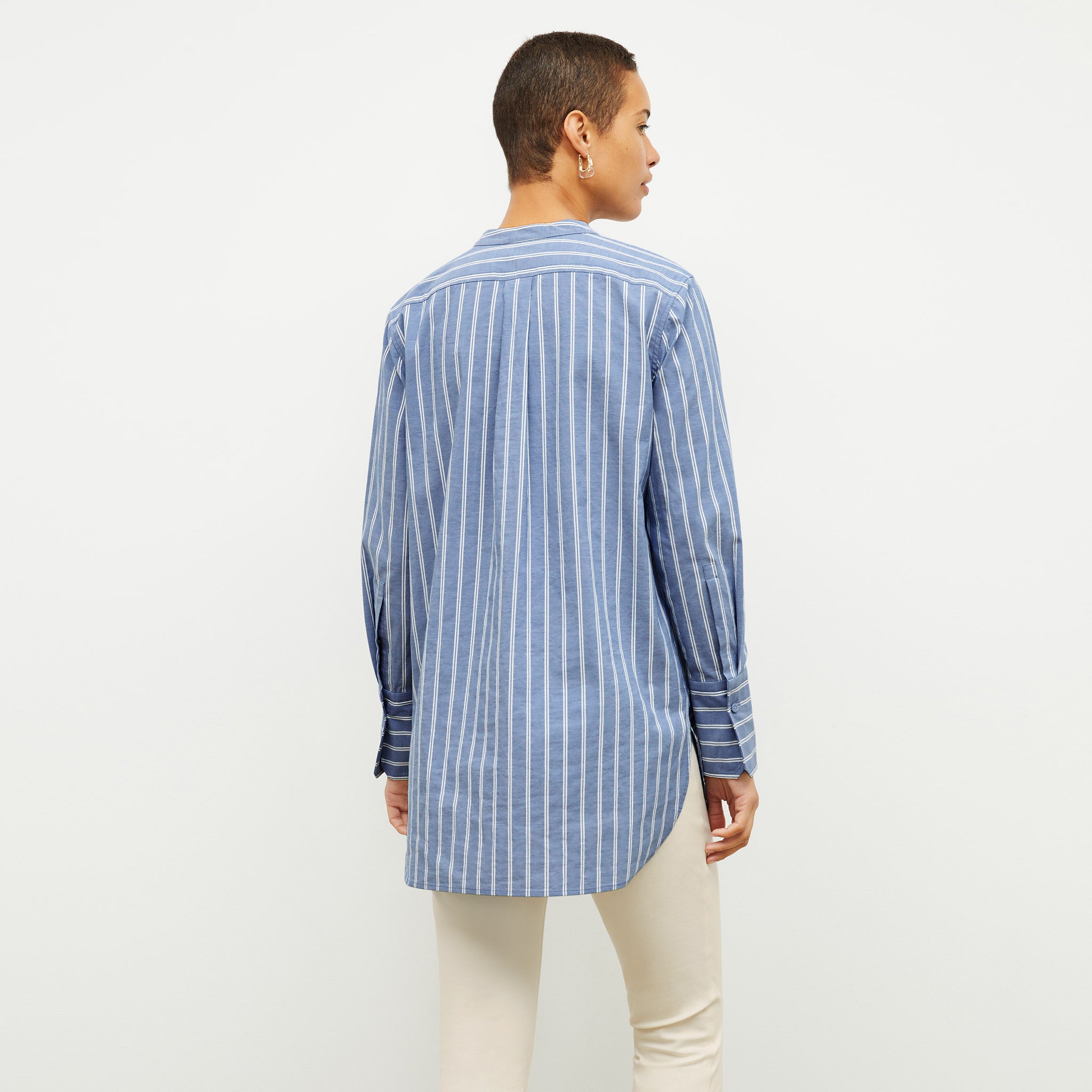 back image of a woman wearing the Nichols shirt in blue and white poplin stripe