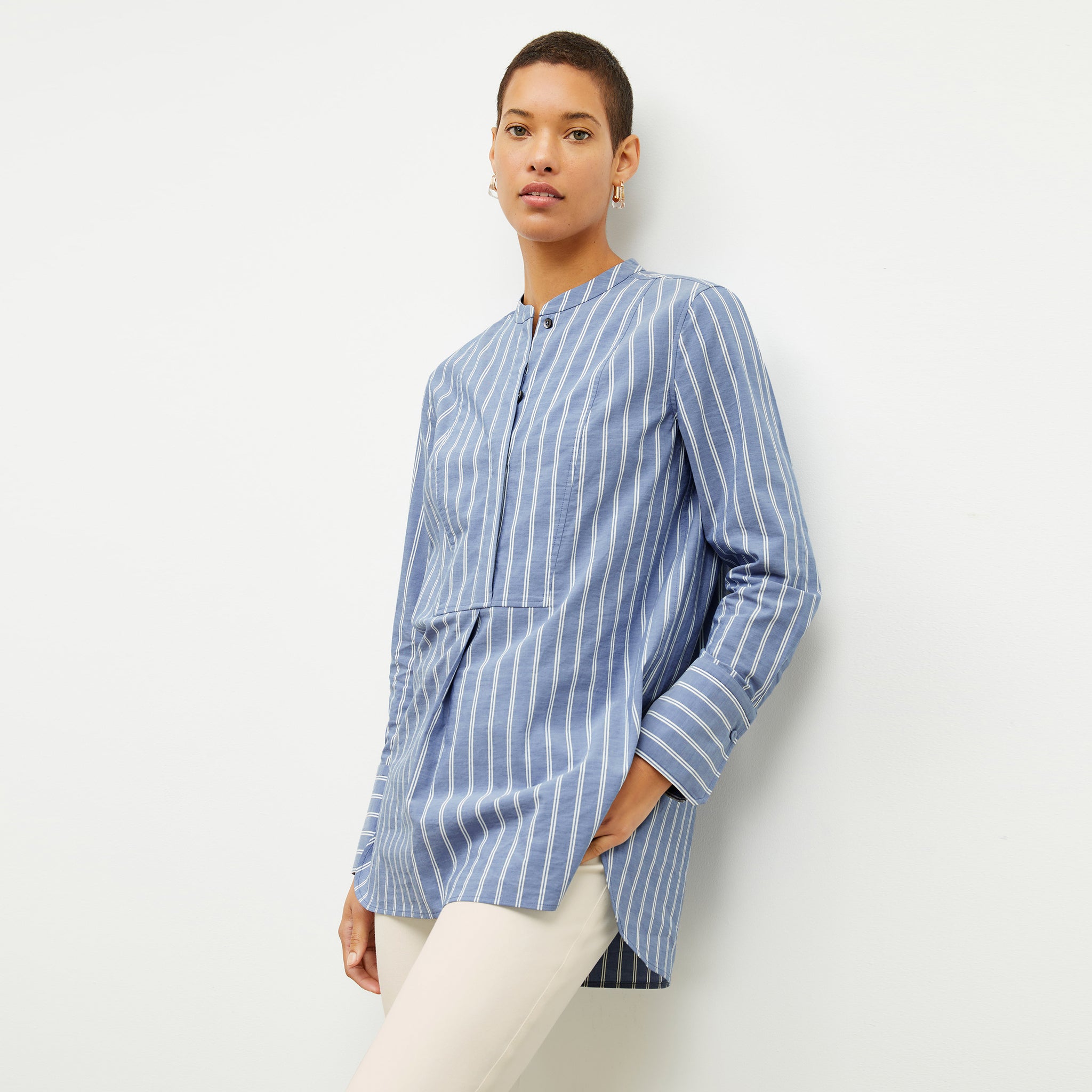 front image of a woman wearing the Nichols shirt in blue and white poplin stripe 