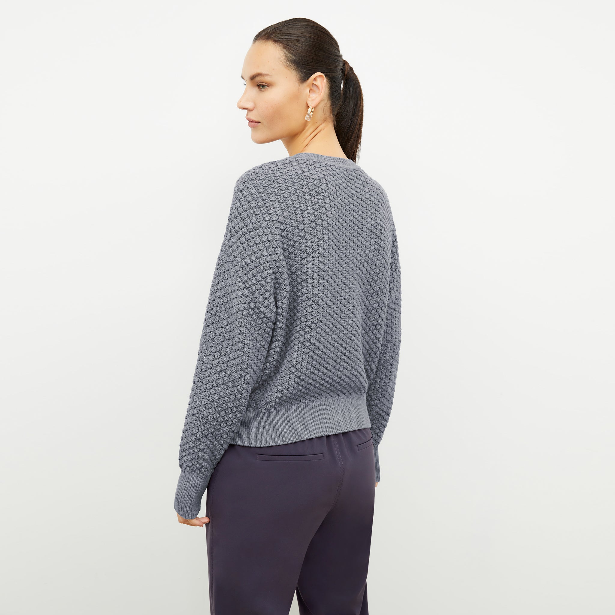 back image of a woman wearing the liam sweater in flint gray