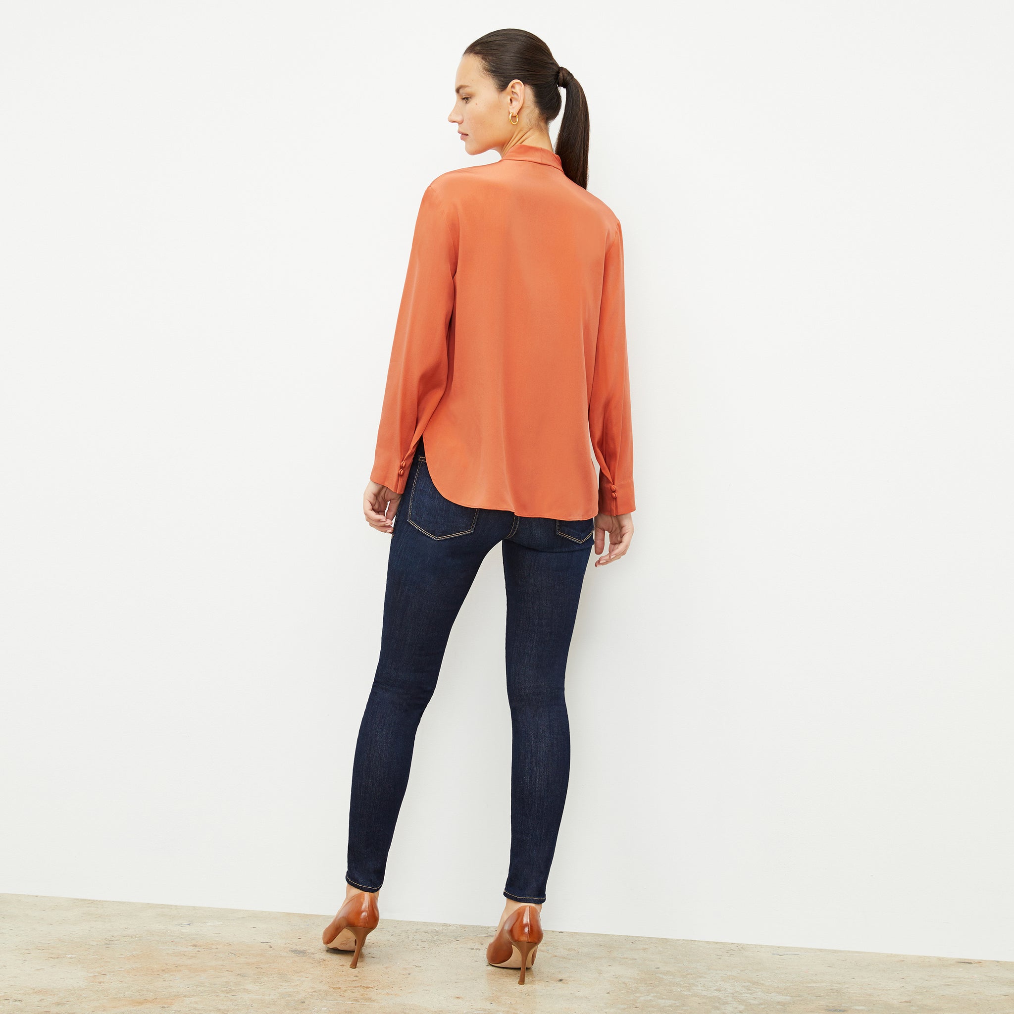 Back image of a woman wearing the Darcy Top in Guava
