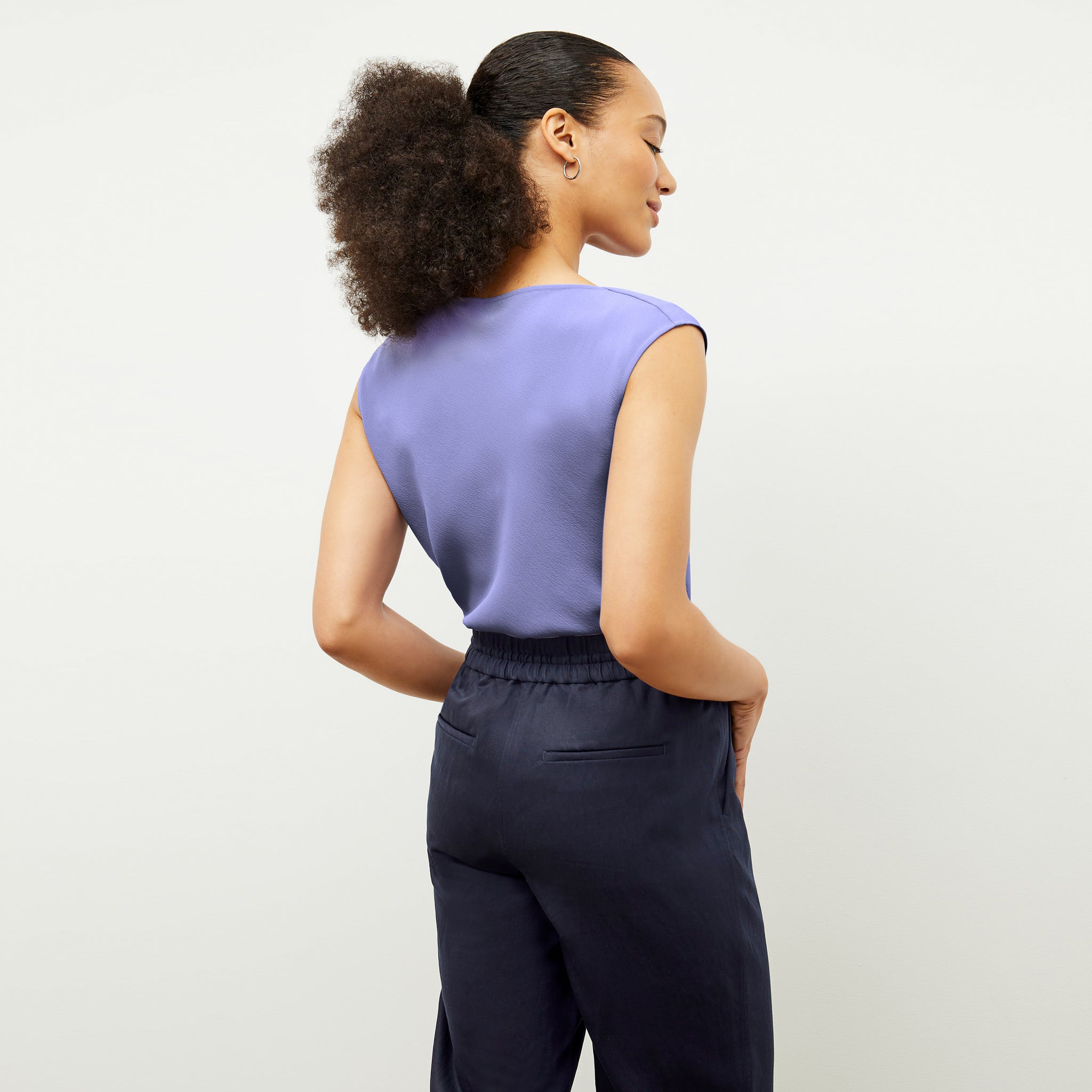 Back image of a woman wearing the Nora Top in Iris