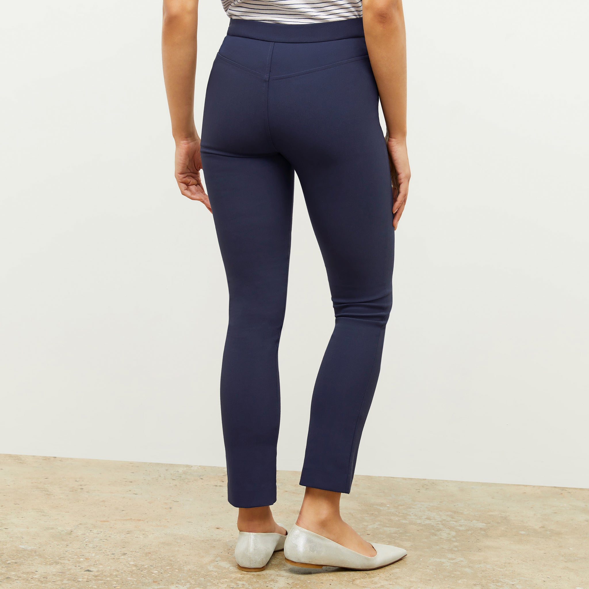 Front image of a woman standing wearing the foster pant in dark navy
