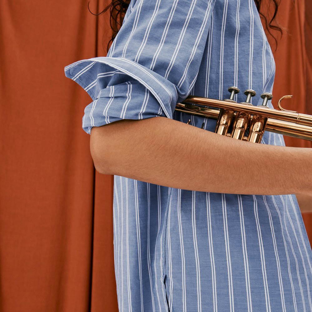 front image of a woman wearing the Nichols shirt in blue and white poplin stripe