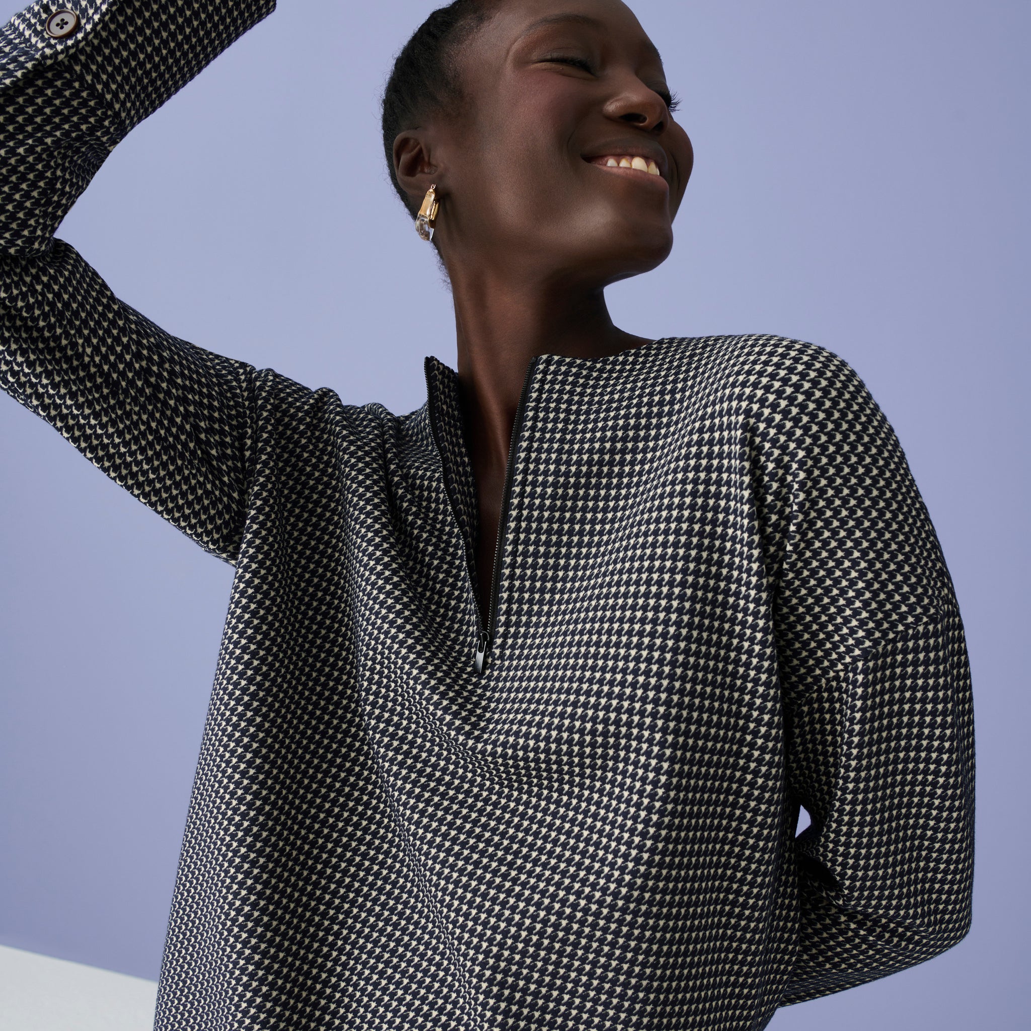 Image of a woman in the Tully Top in Houndstooth with her arm up