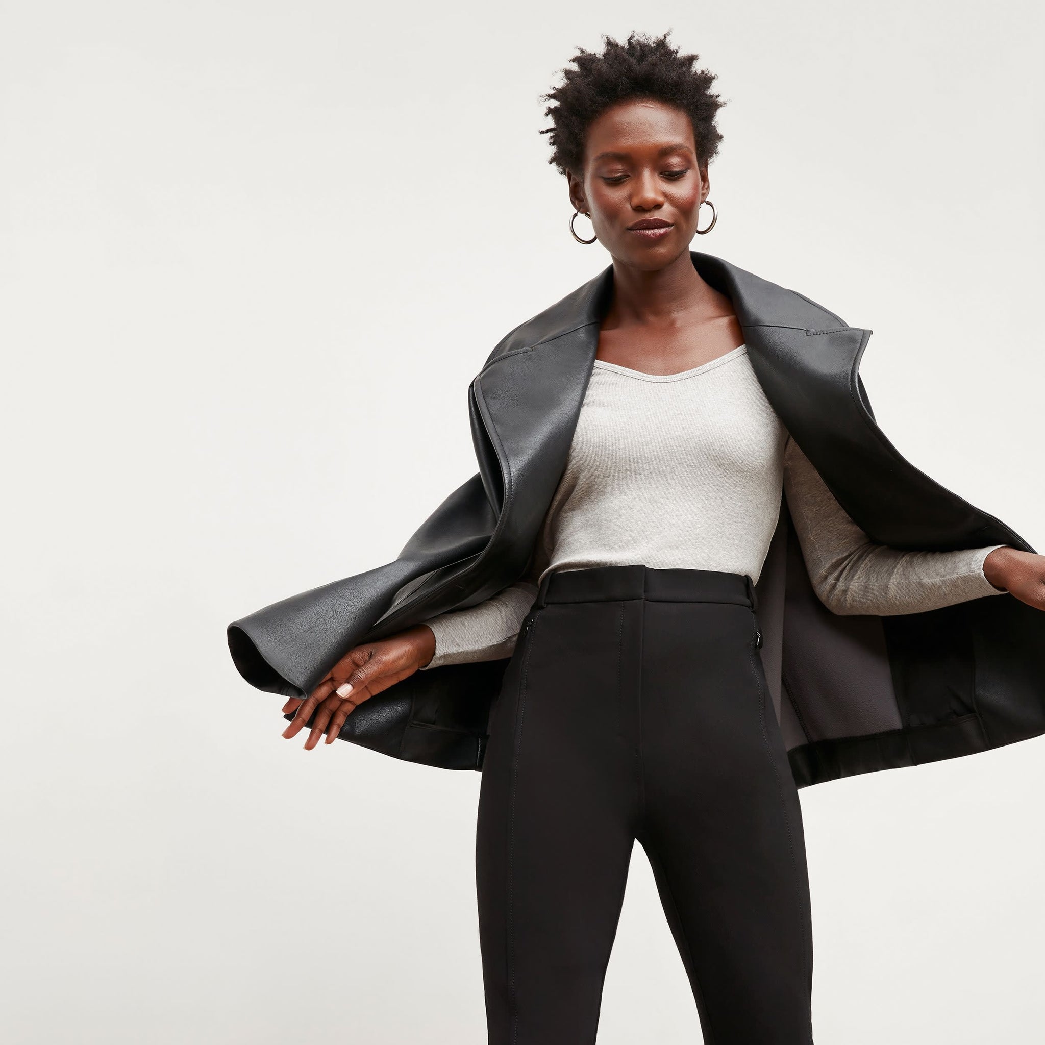 Front image of a woman standing wearing the Alphonso Jacket—Vegan Leather in Black