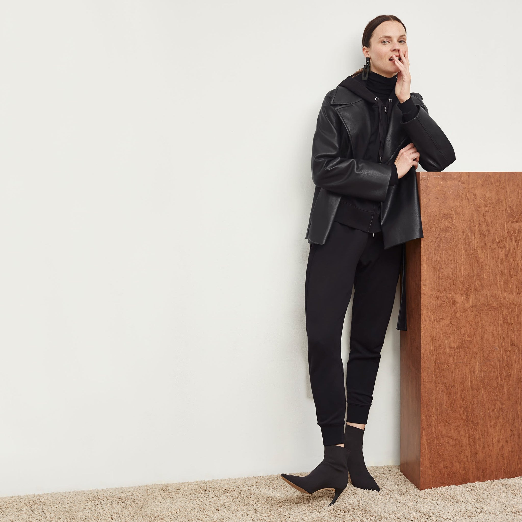 Front image of a woman standing wearing the Alphonso Jacket—Vegan Leather in Black