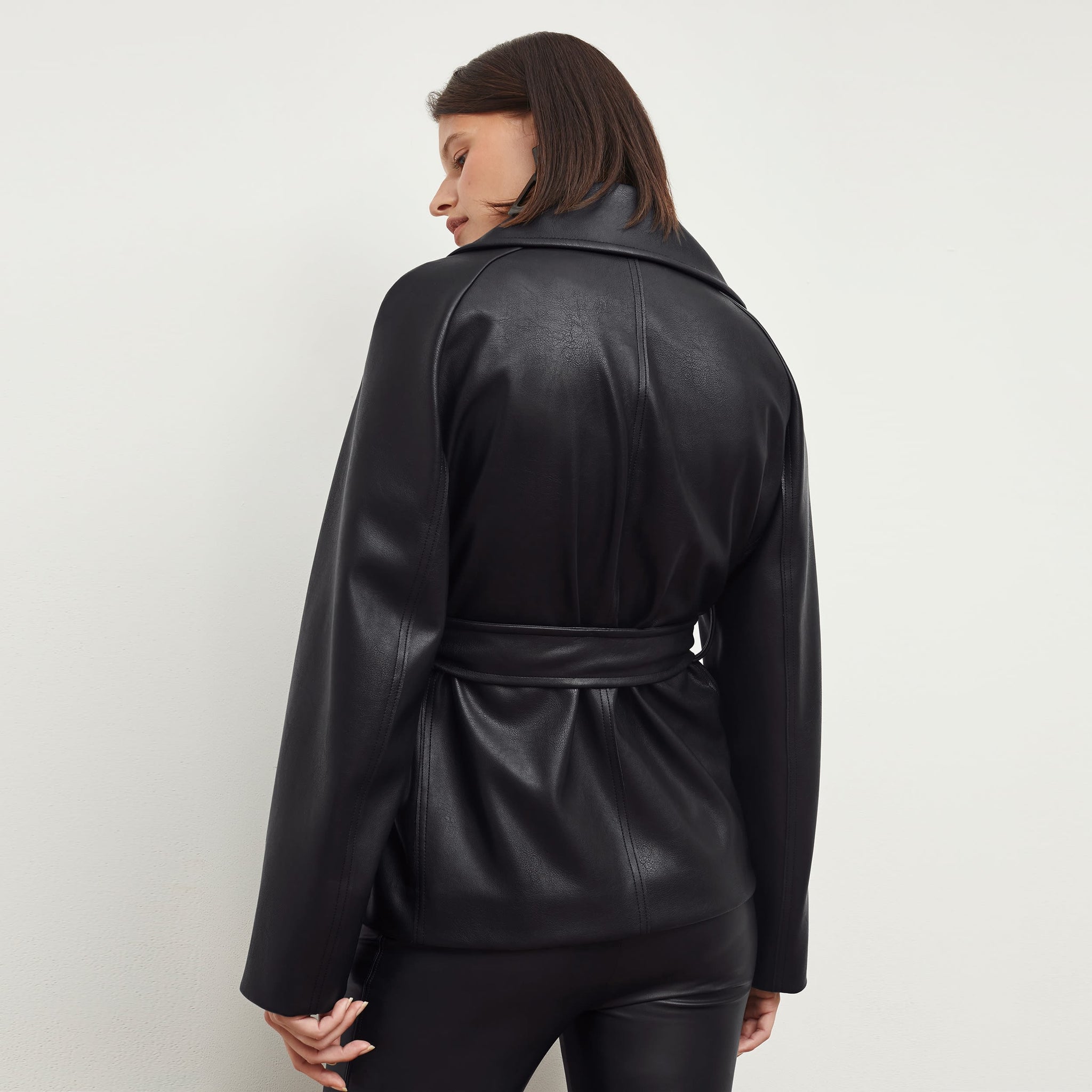 Back image of a woman standing wearing the Alphonso Jacket—Vegan Leather in Black