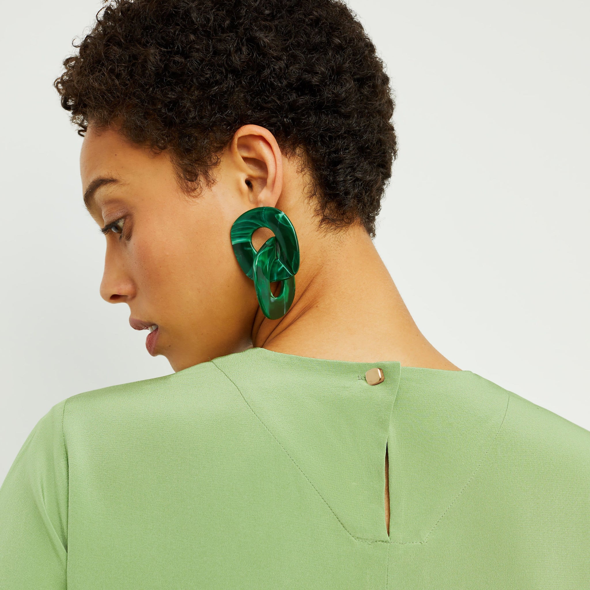 Detail image of a woman standing wearing the Annika Tee—Washable Silk in Cactus