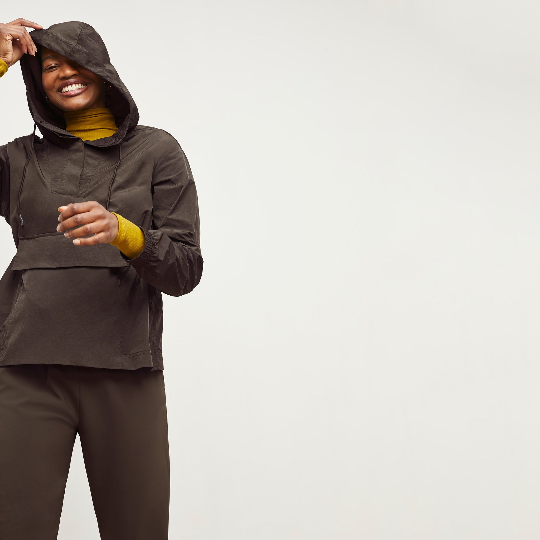 Front image of a woman standing wearing the Britt Hoodie—AirTech in Dark Moss
