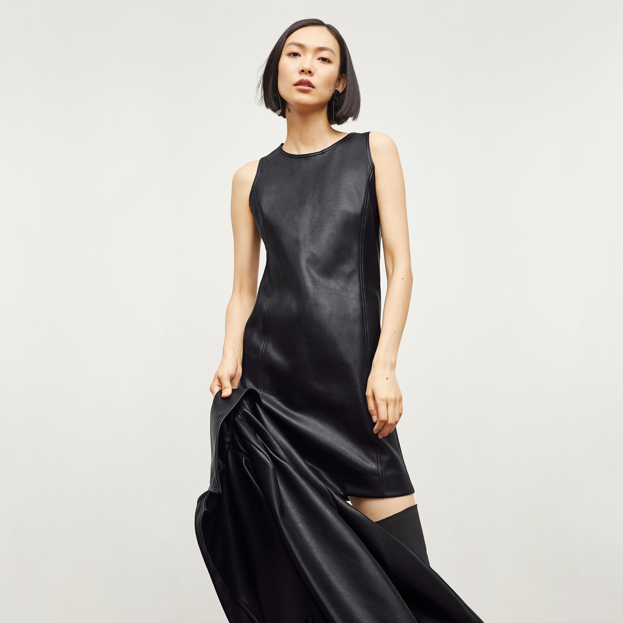 Front image of a woman standing wearing the Chloe Dress—Vegan Leather in Black 