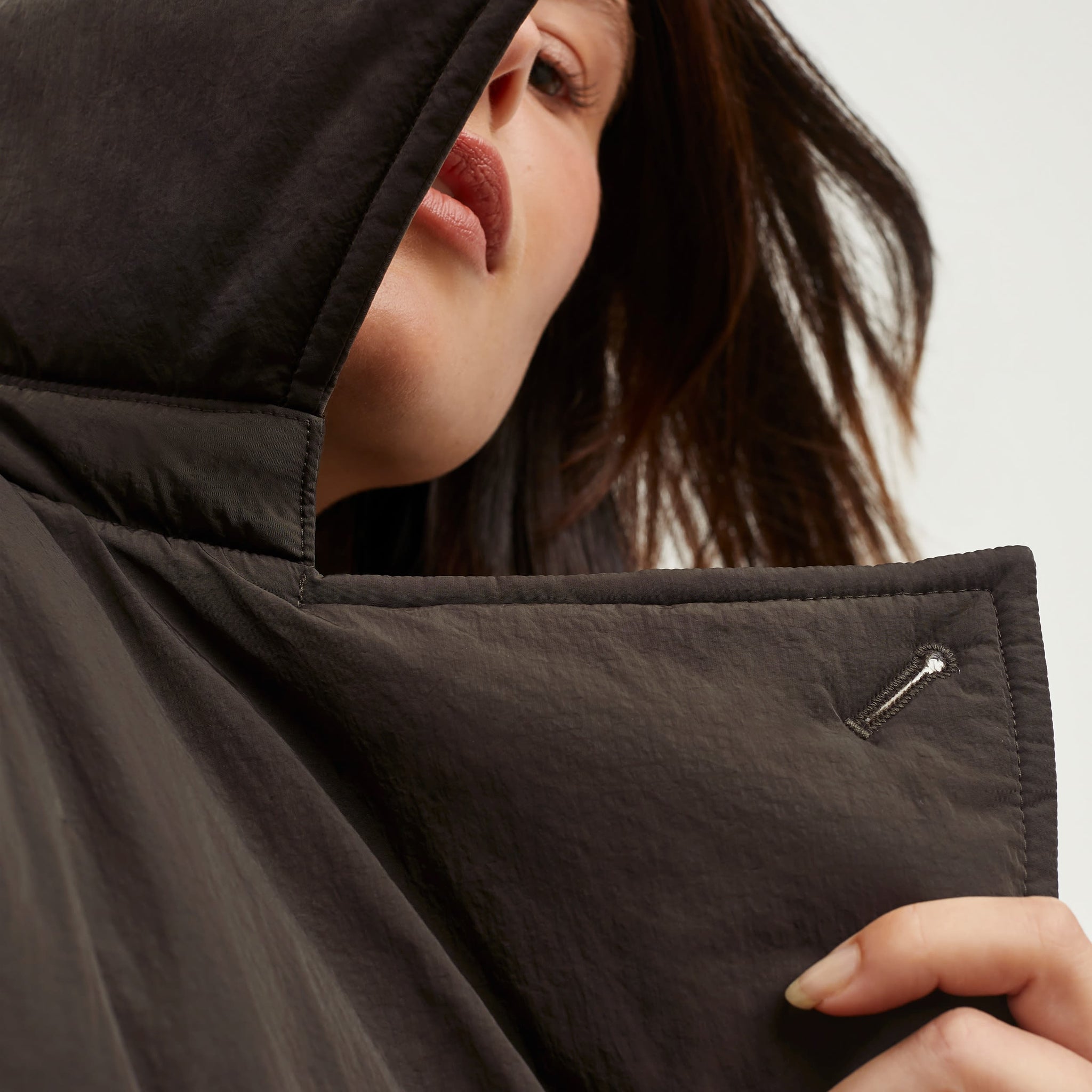 Detail image of a woman standing wearing the Clark Parka—AirTech in Dark Moss
