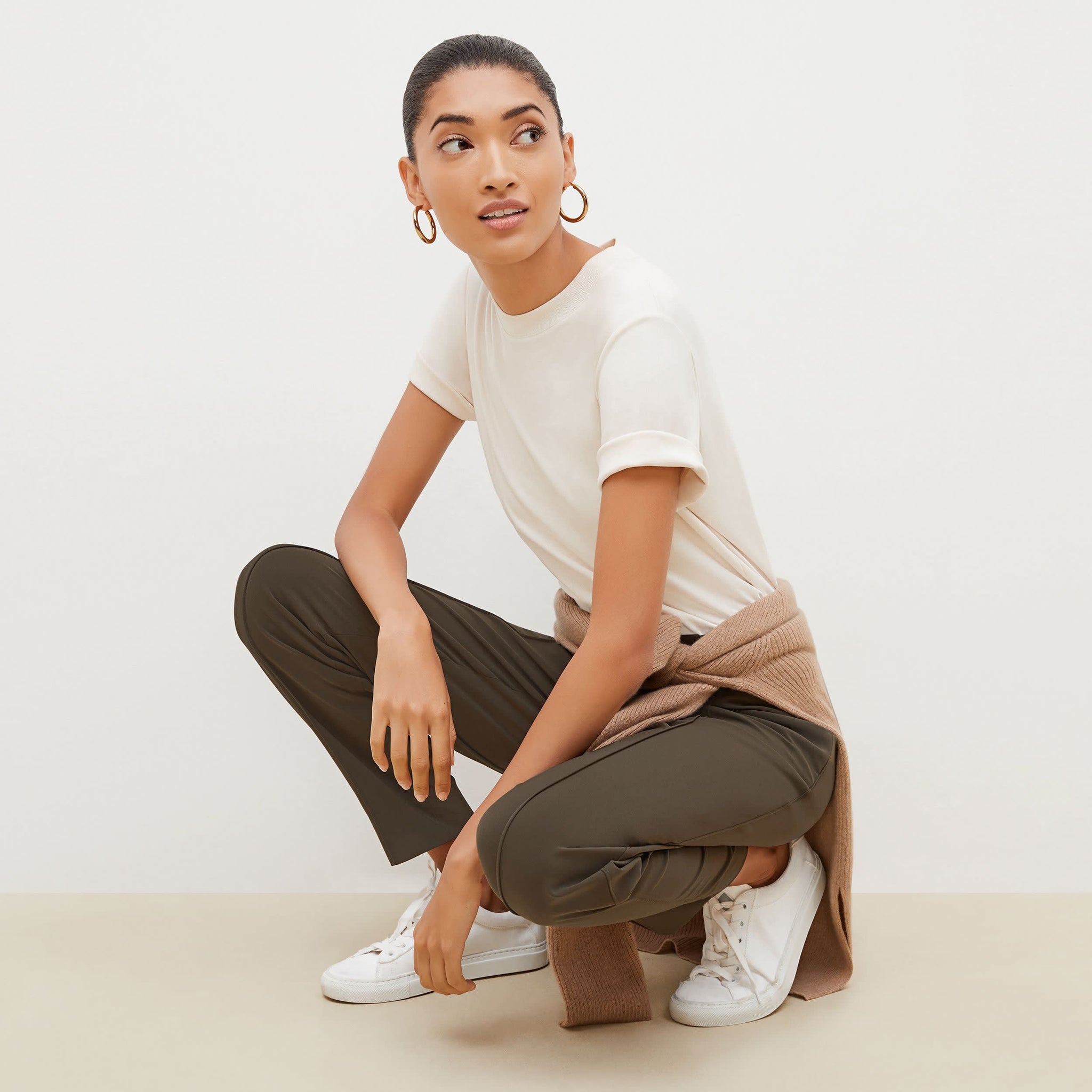 Side image of a woman squatting wearing the colby pant in olive