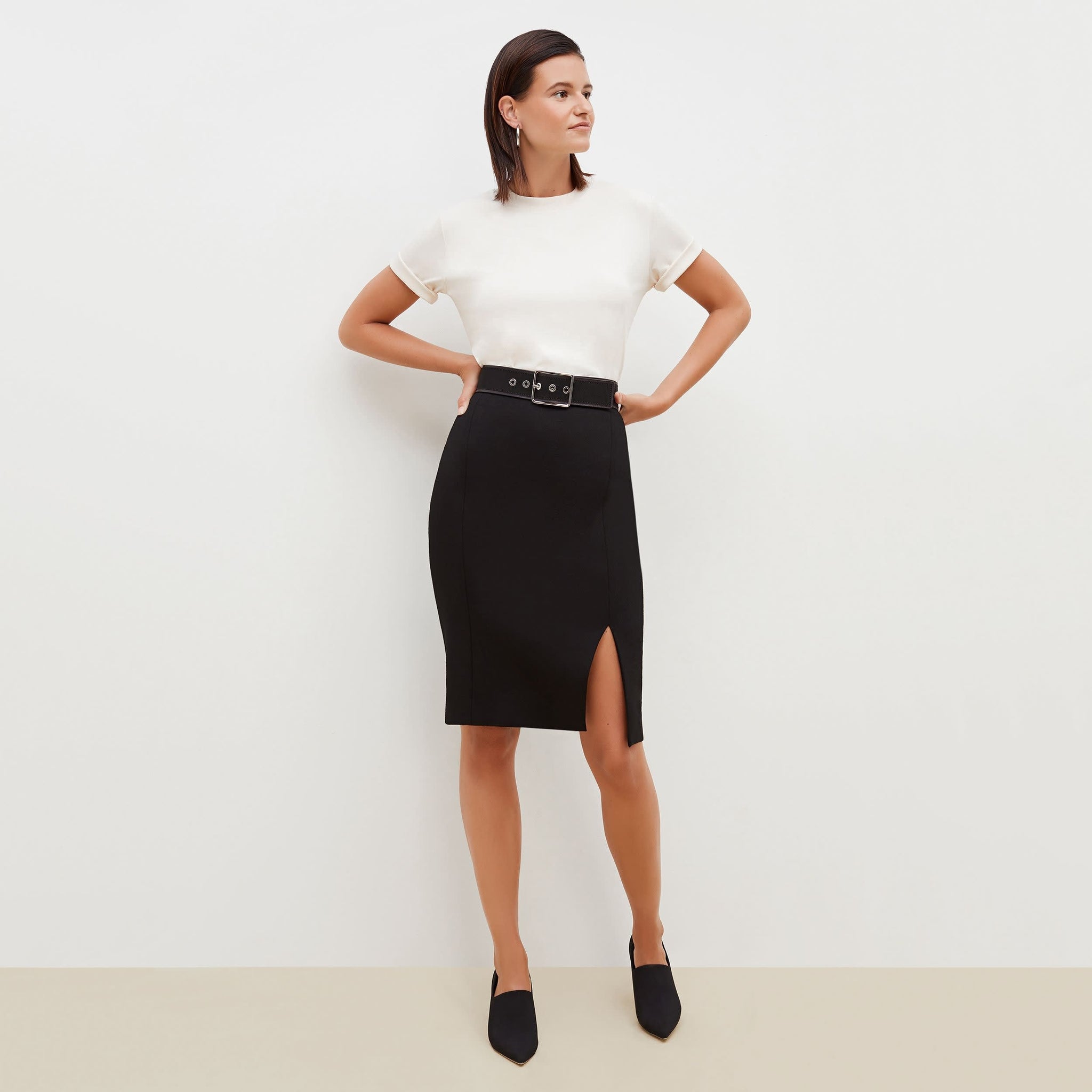 Front image of a woman standing wearing the Cortlandt Skirt--Worth in Black