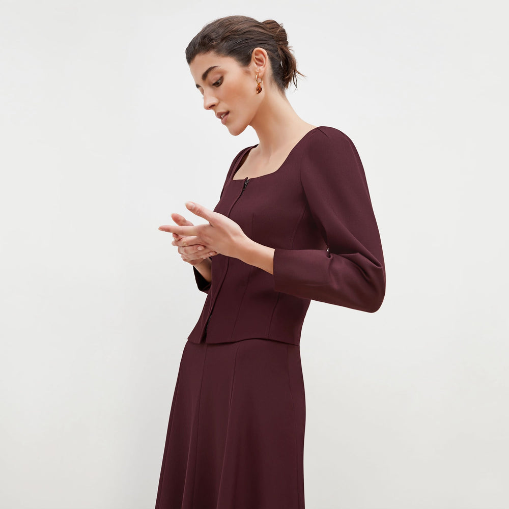 Side image of a woman standing wearing the Dawn Top-Sharkskin in garnet