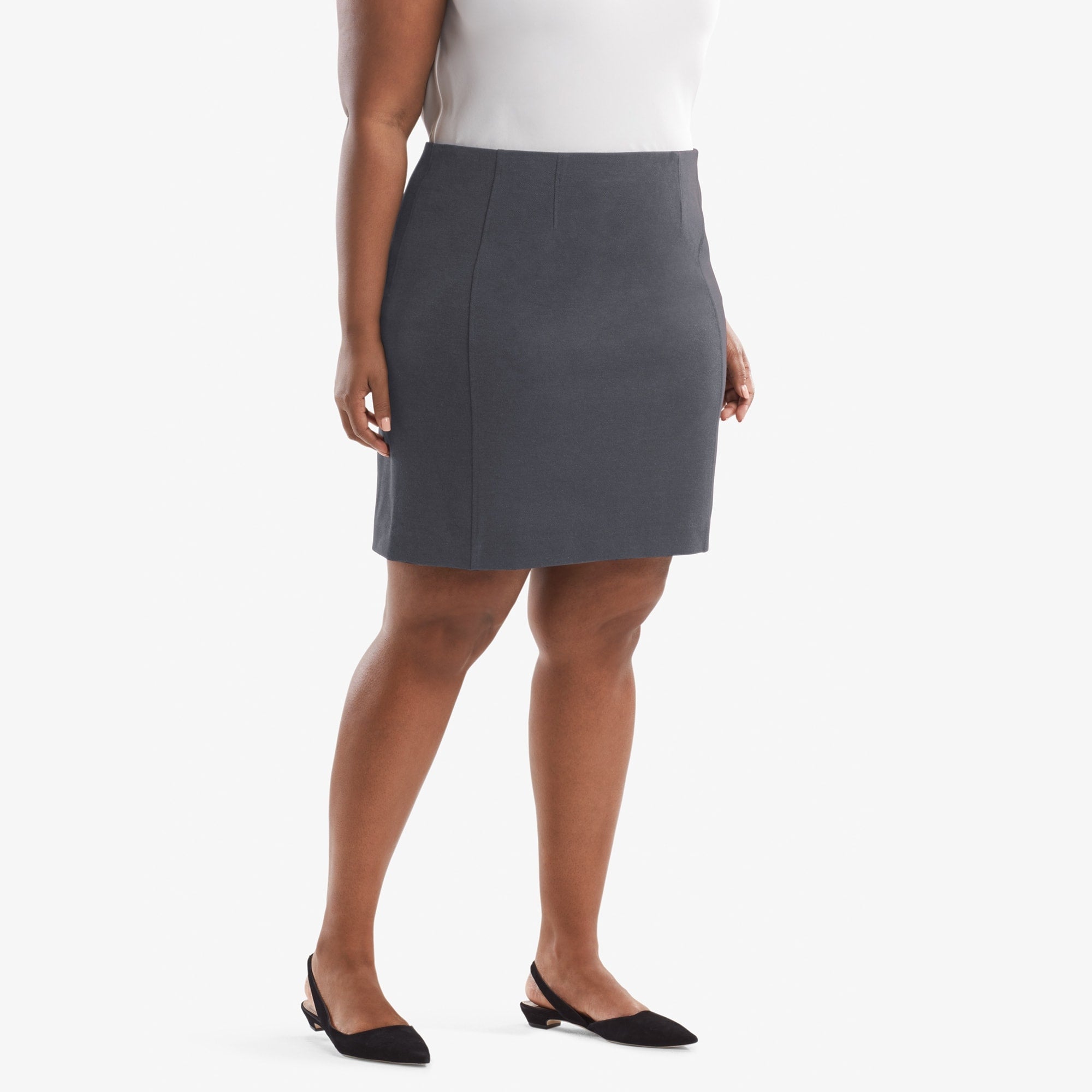 Side image of a woman standing wearing the Crosby skirt textured ponte in Charcoal