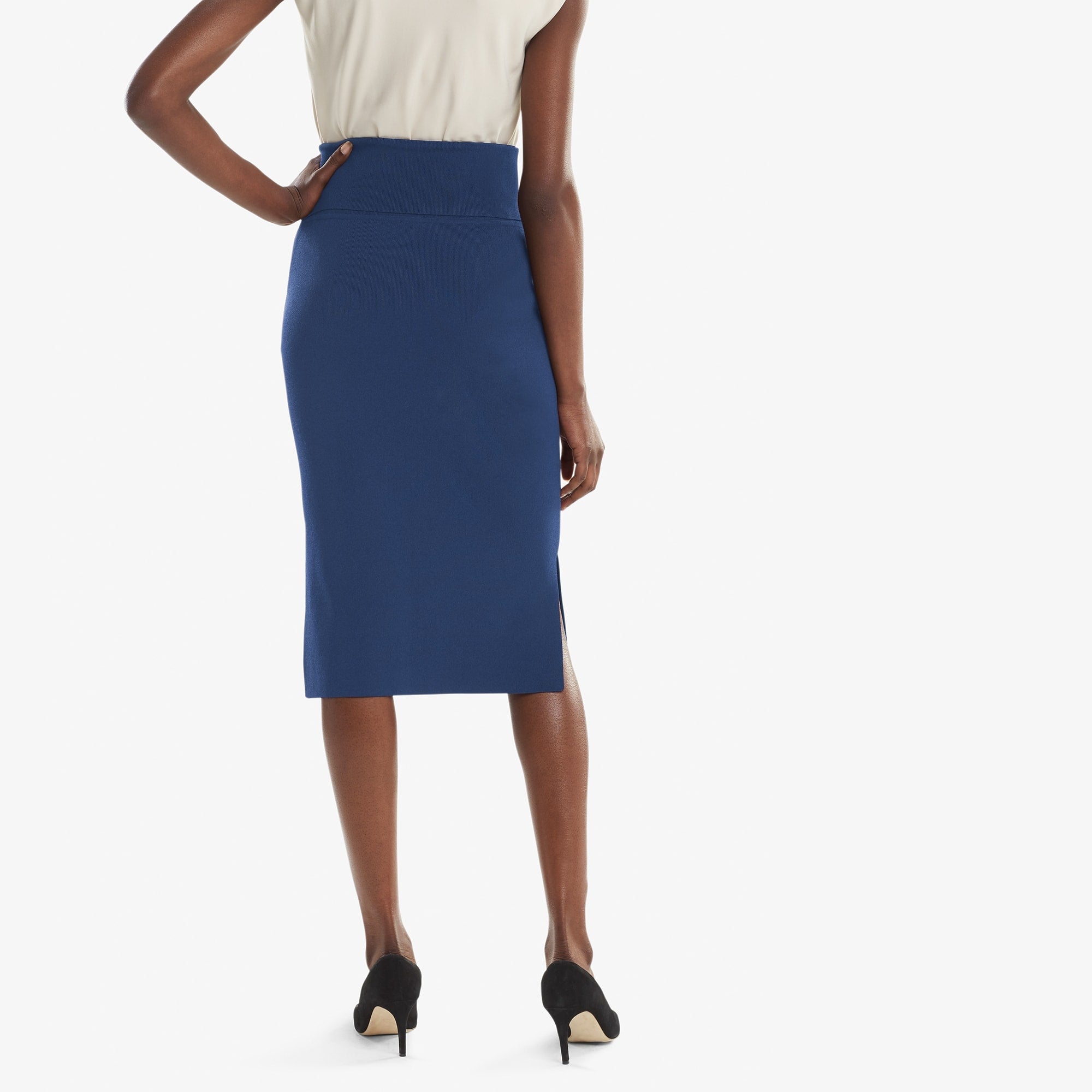 Back image of a woman standing wearing the Harlem skirt in Regent blue