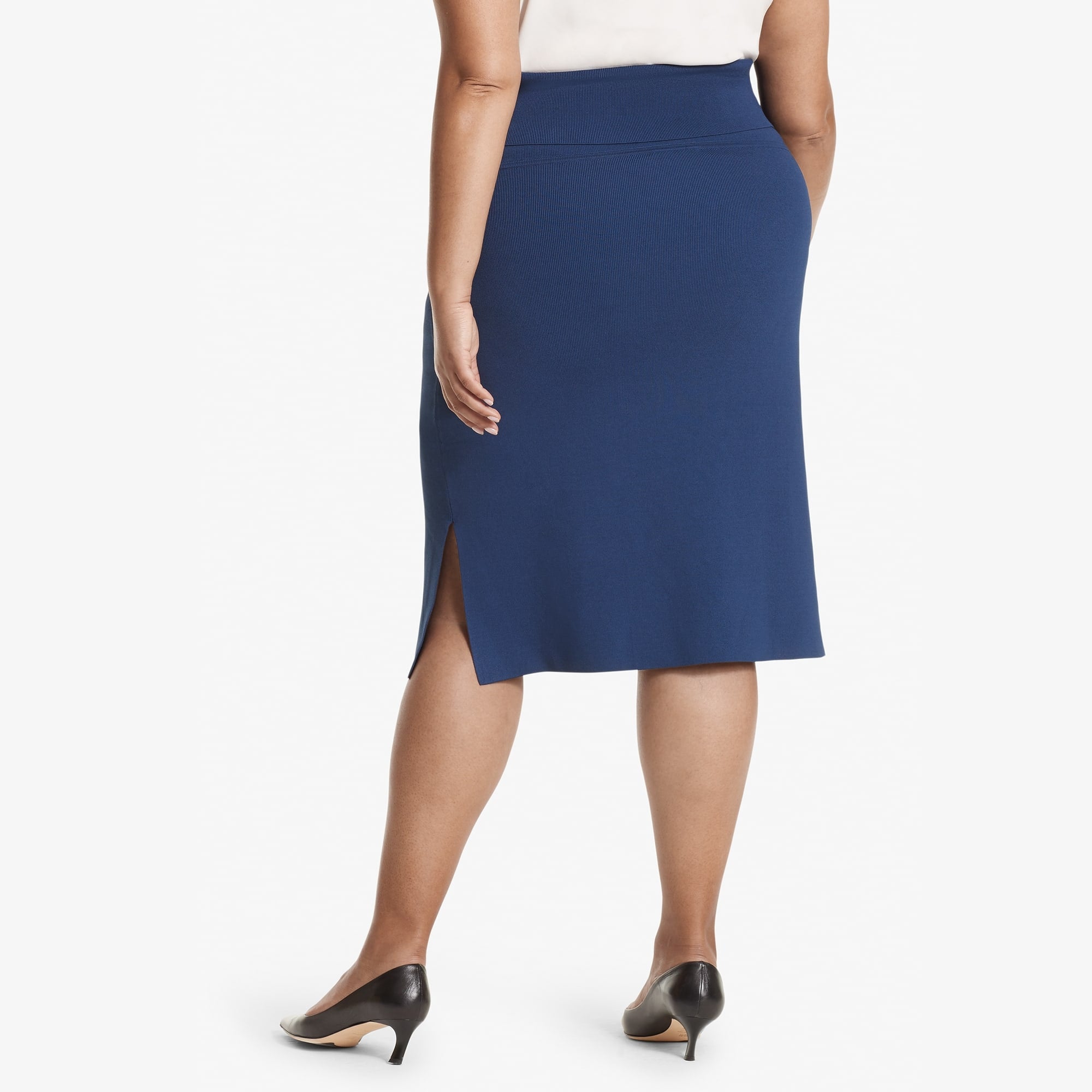 Back image of a woman standing wearing the Harlem skirt in Regent blue