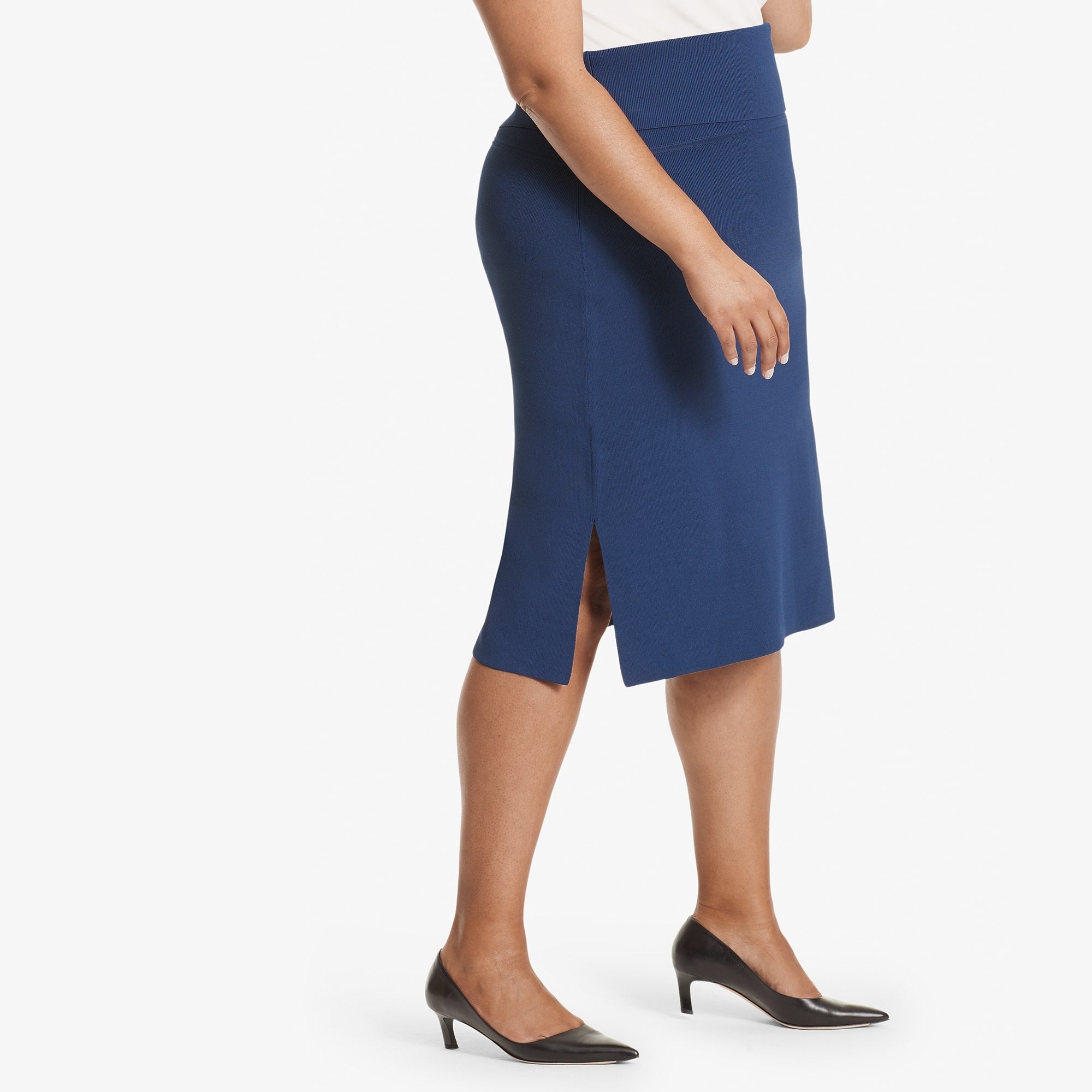 Side image of a woman standing wearing the Harlem skirt in Regent blue