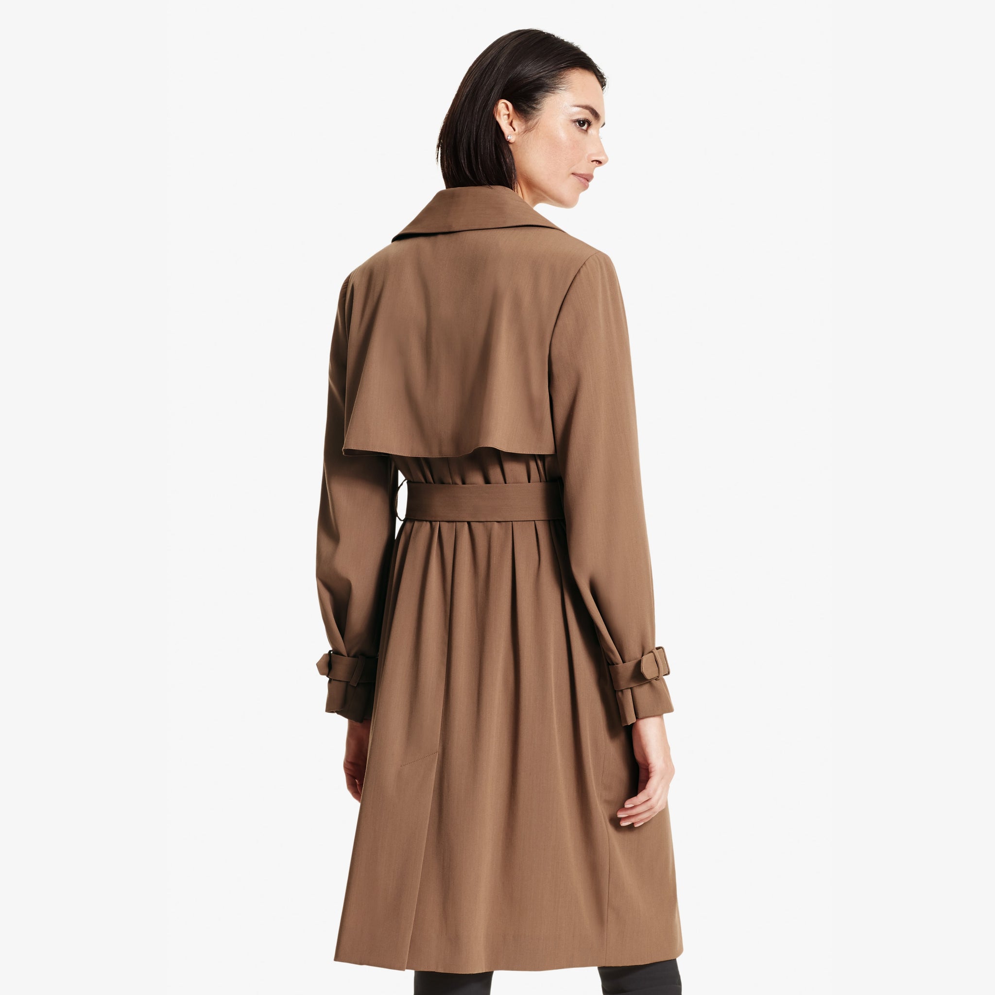 Back image of a woman standing wearing the Jensen trench in Saddle