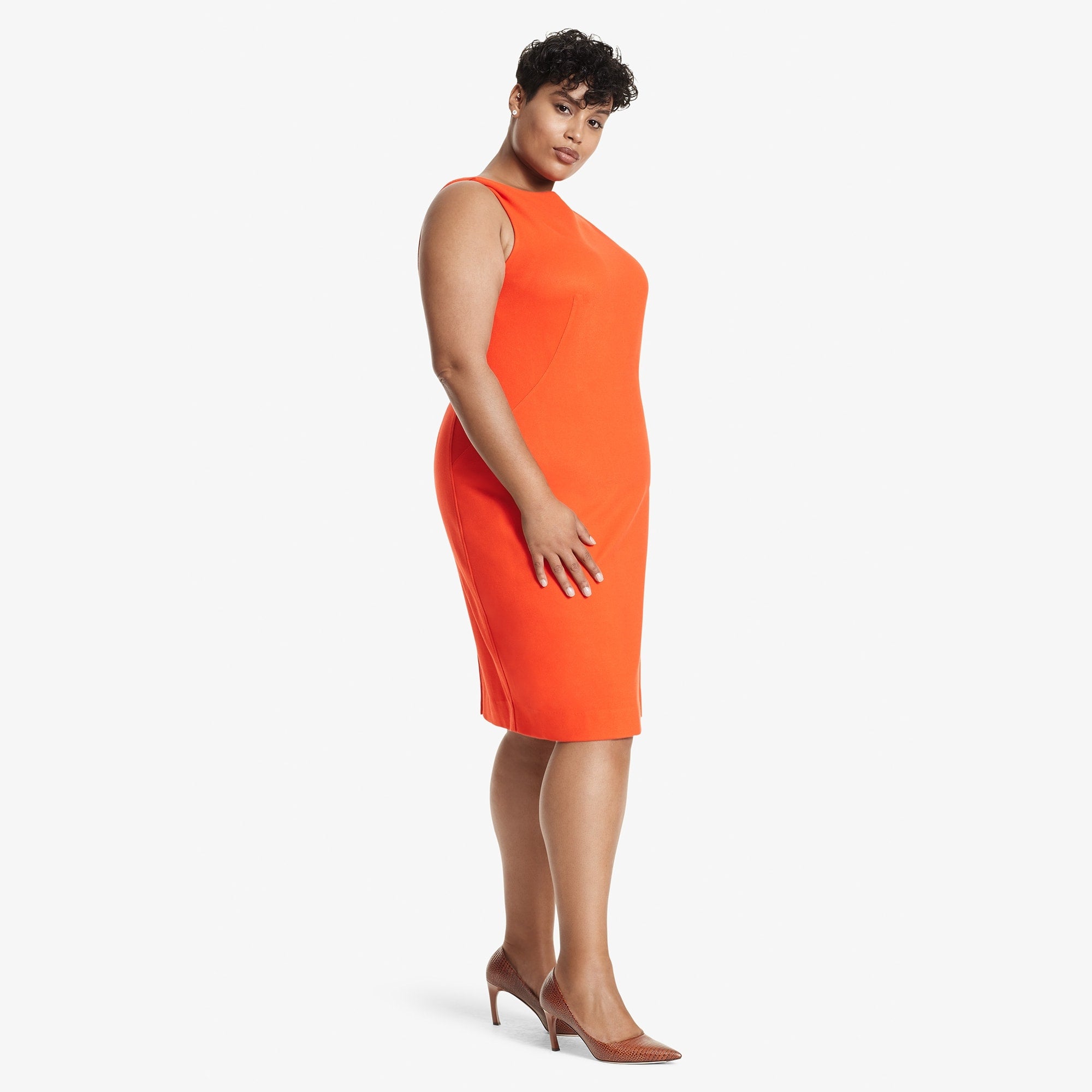 Side image of a woman standing wearing the Lydia dress textured ponte in Tangerine