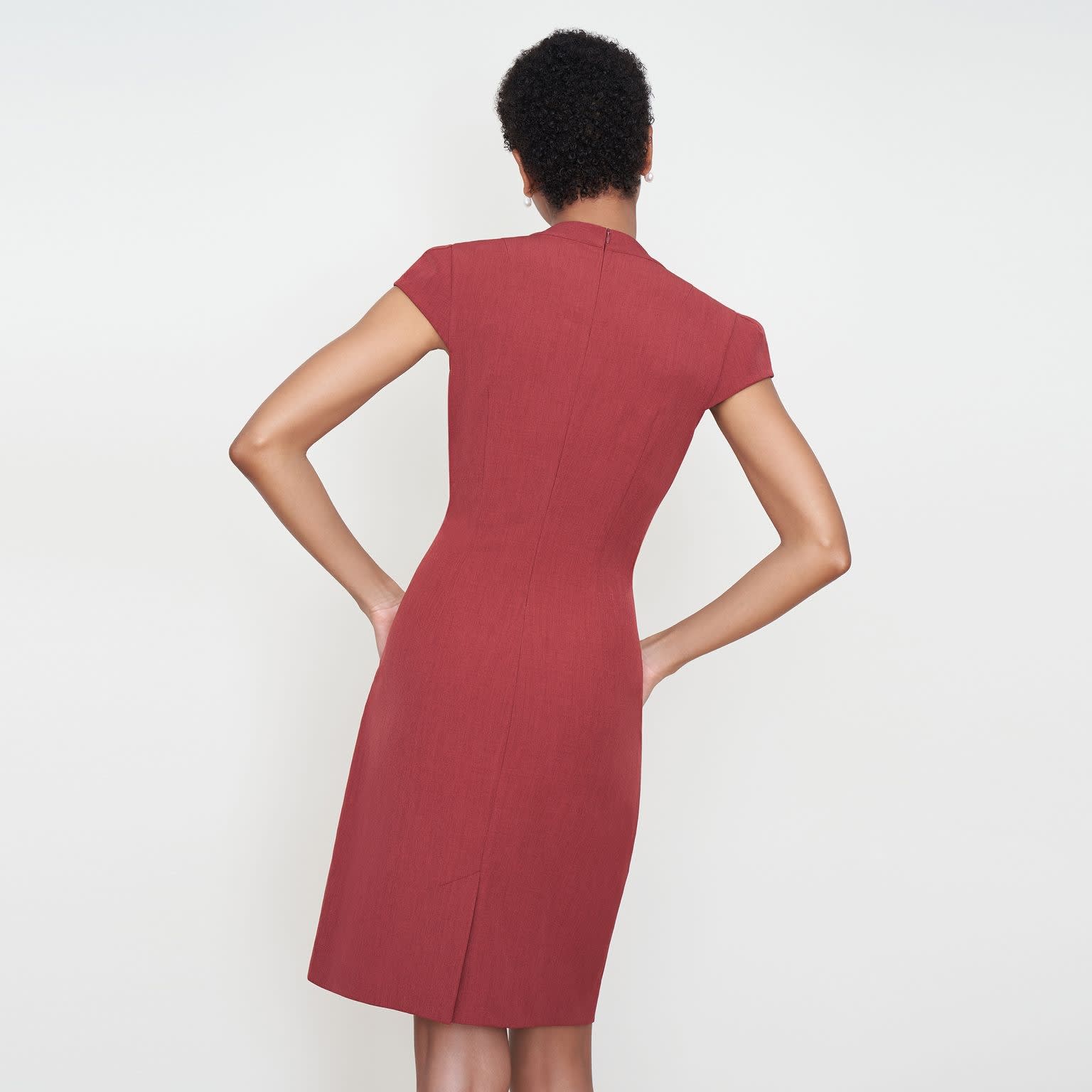 Back image of a woman standing wearing the Felisa dress in Brick Red