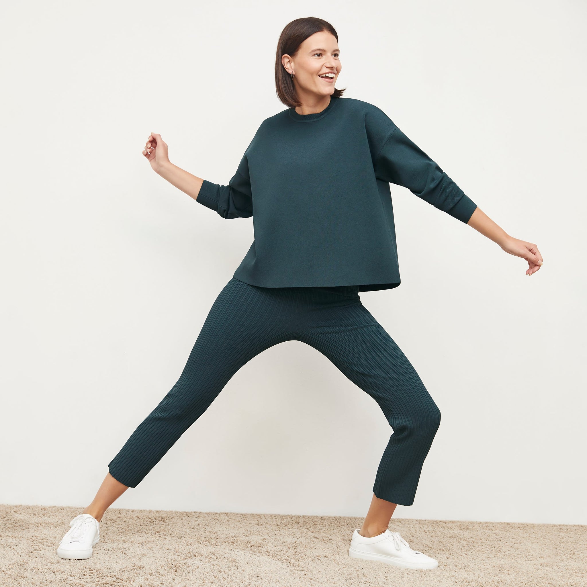 Front image of a woman standing wearing the Finley Legging—Ribbed Jardigan Knit in Deep Sea