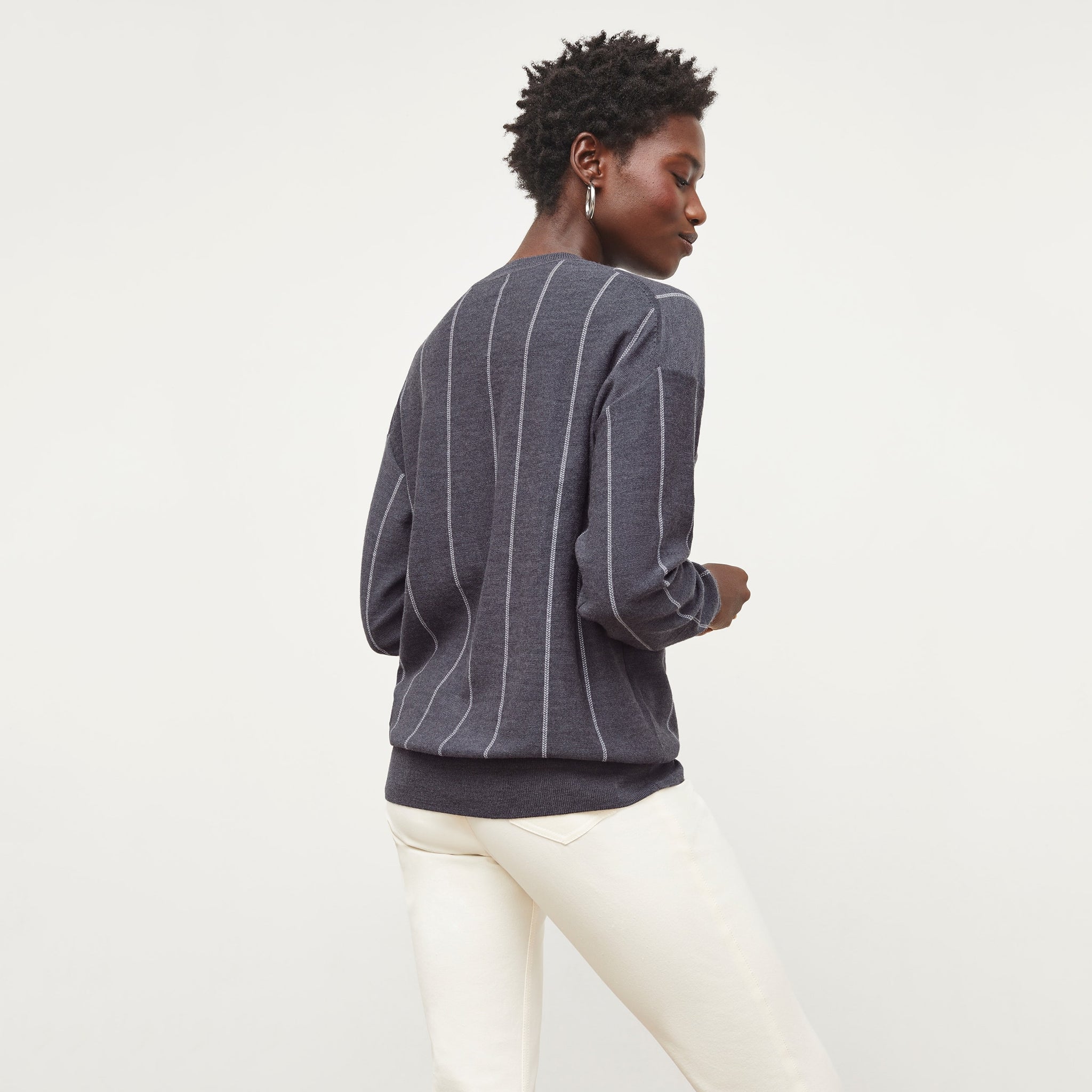 Back image of a woman standing wearing the Ingola Sweater—Braided Stripe in Charcoal / Ivory