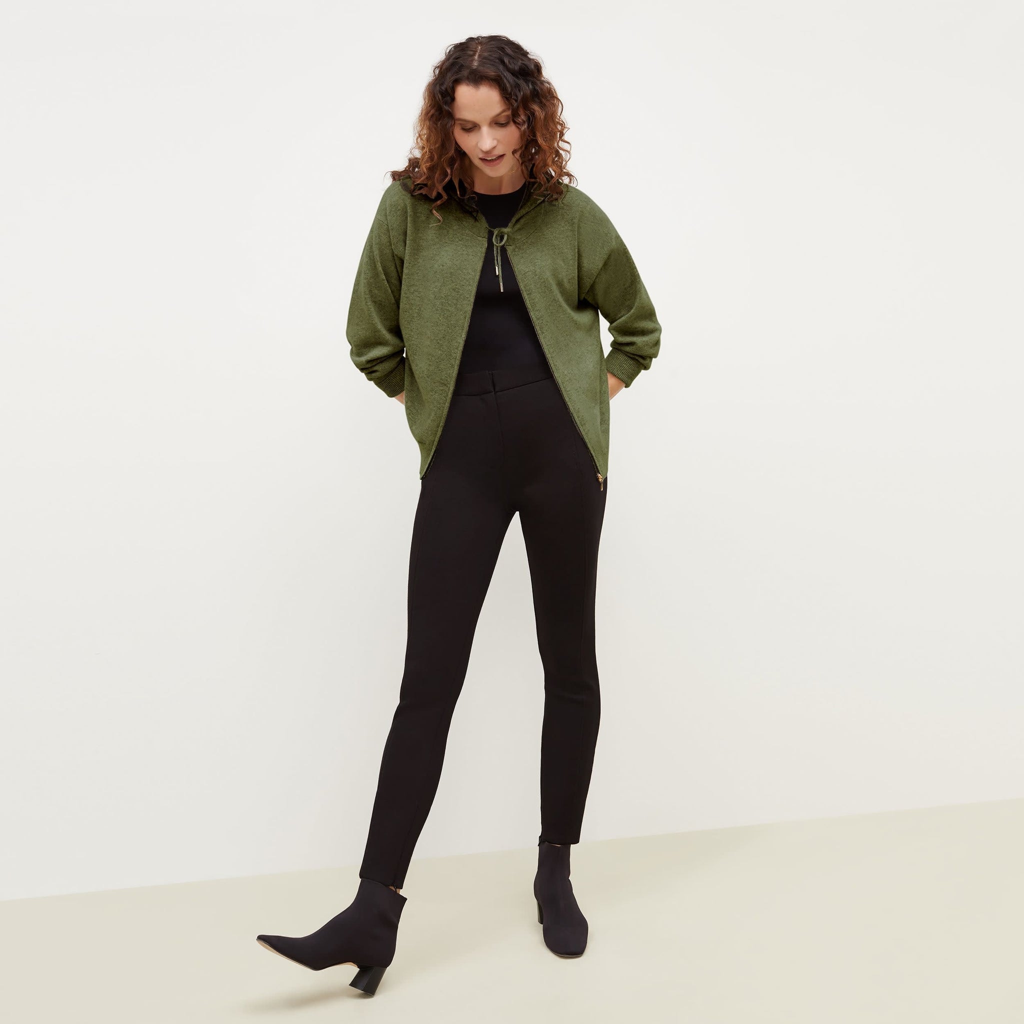 Front image of a woman standing wearing the Judith Hoodie—Cashmere in Olive