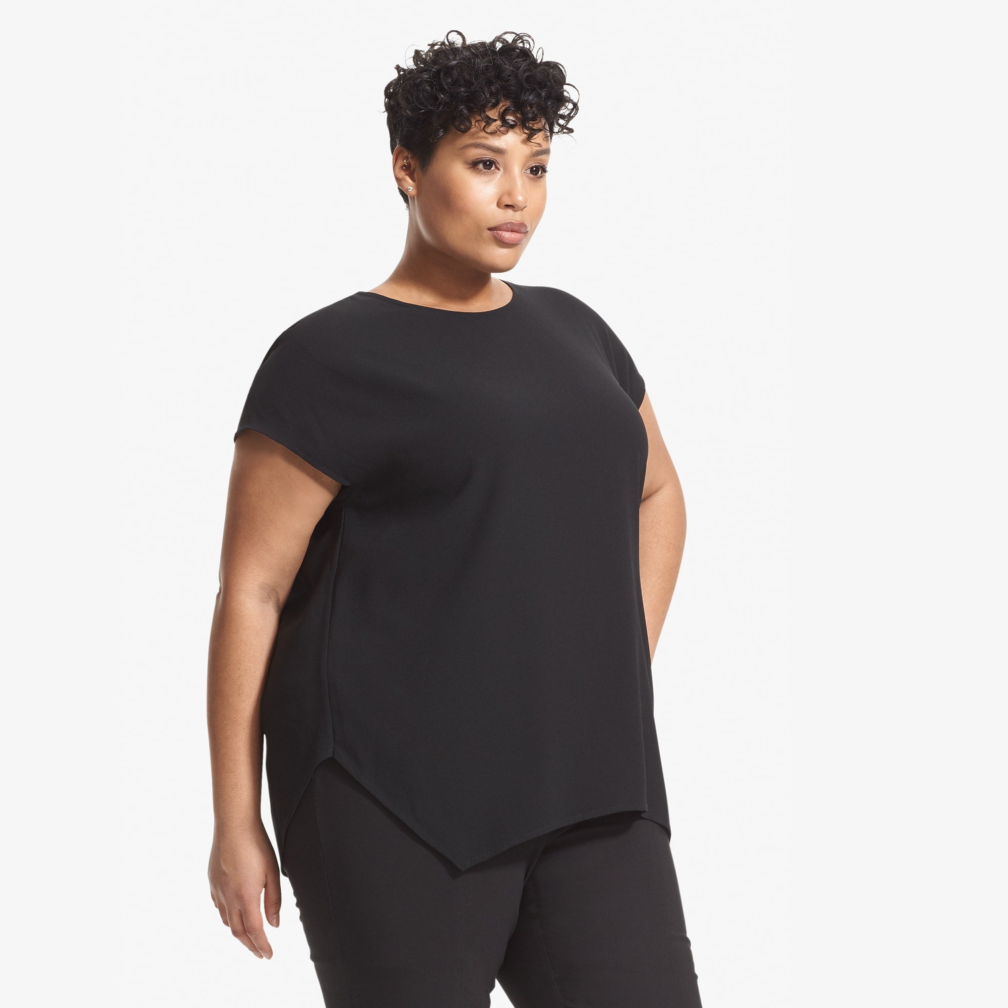 Side image of a woman standing wearing the Didion top in black