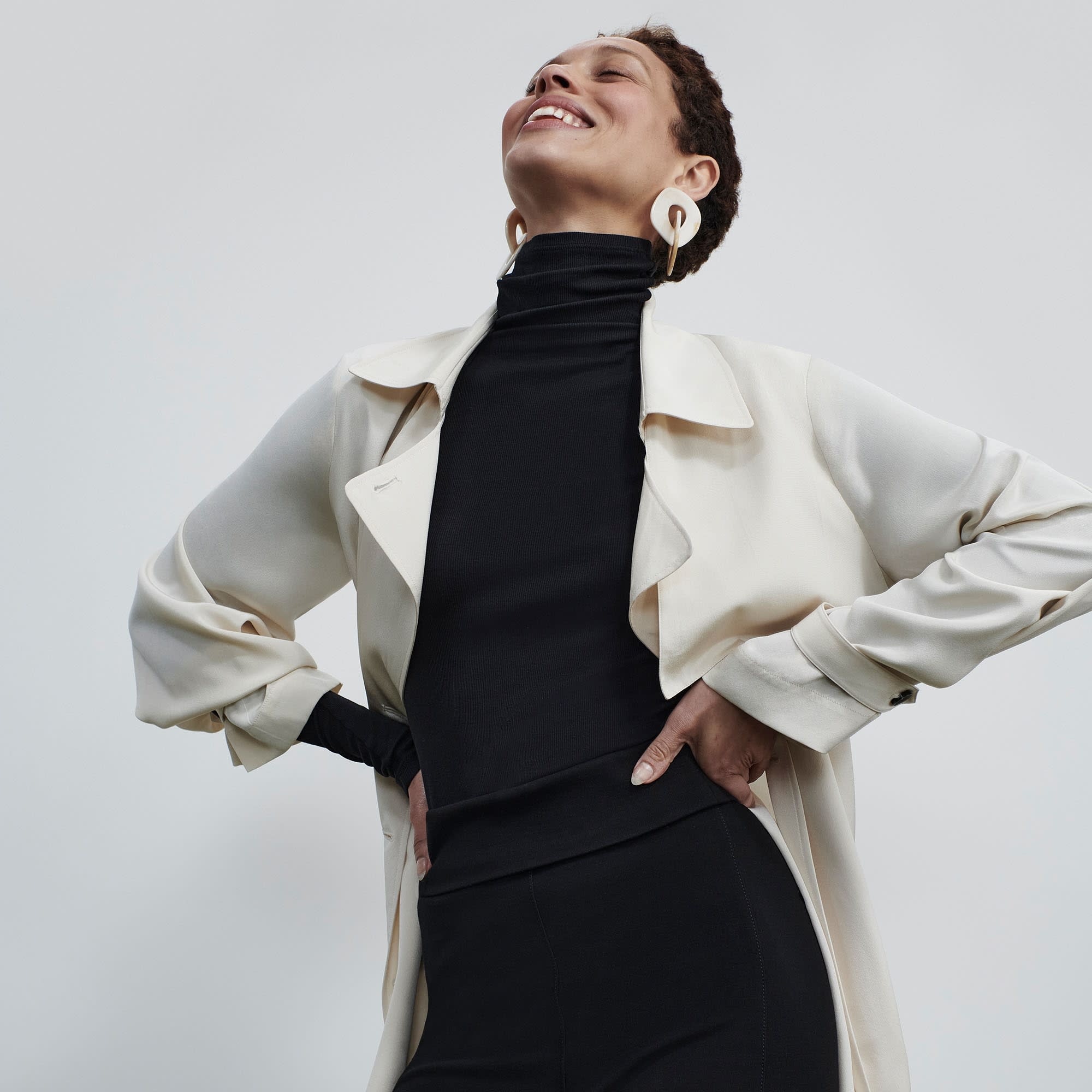 Front image of a woman standing wearing the Jensen Trench—SustainSilk in Pearl