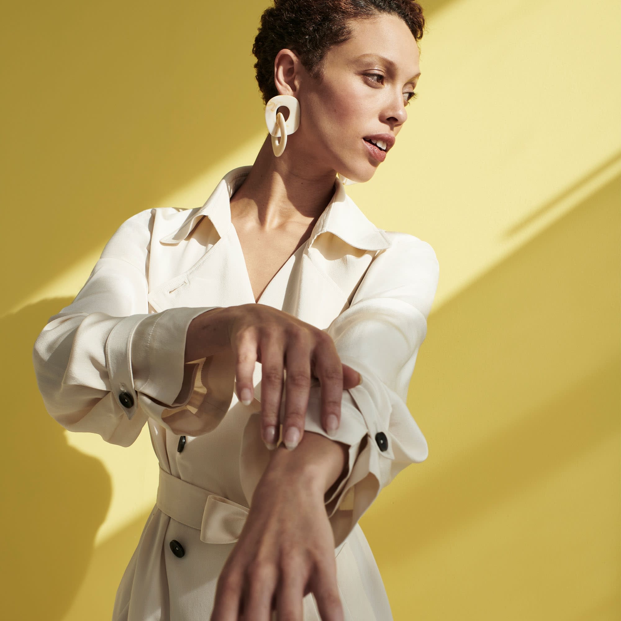 Front image of a woman standing wearing the Jensen Trench—SustainSilk in Pearl