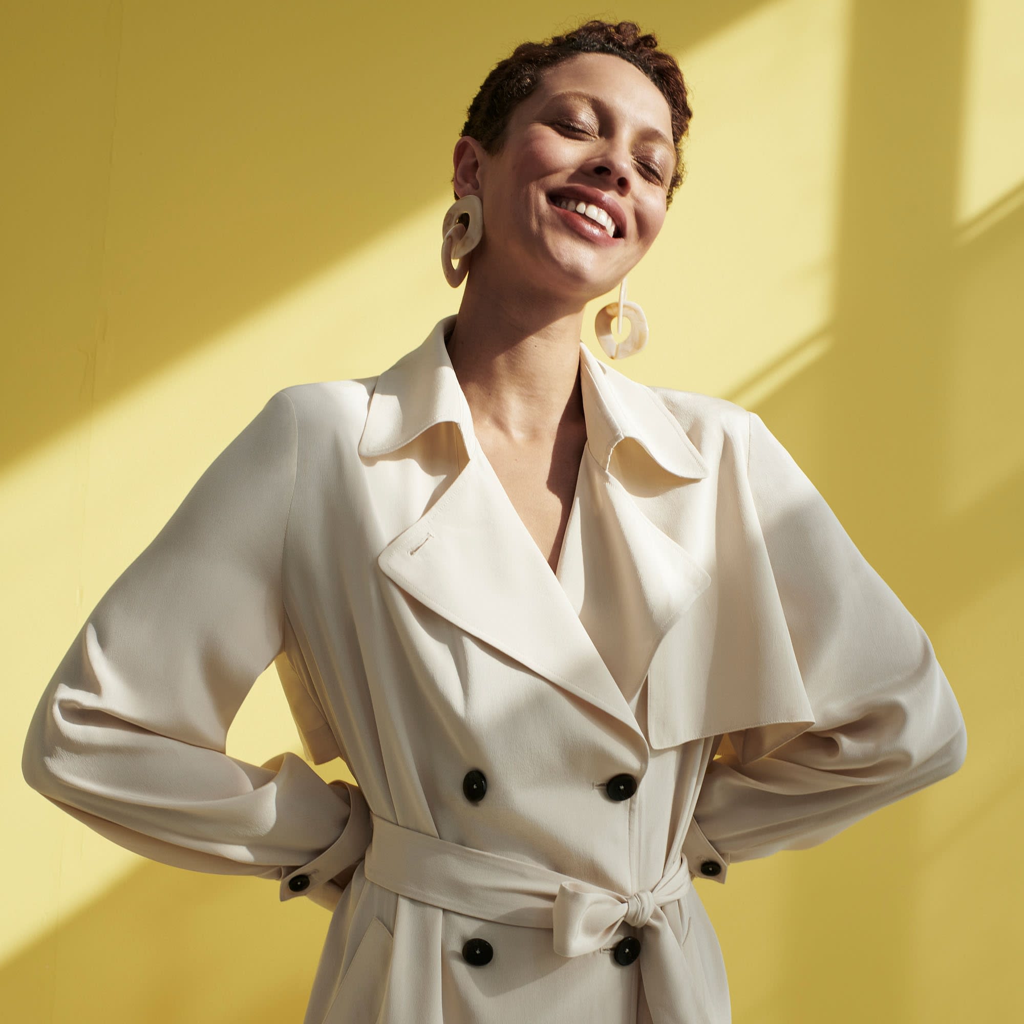 Front image of a woman standing wearing the Jensen Trench—SustainSilk in Pearl