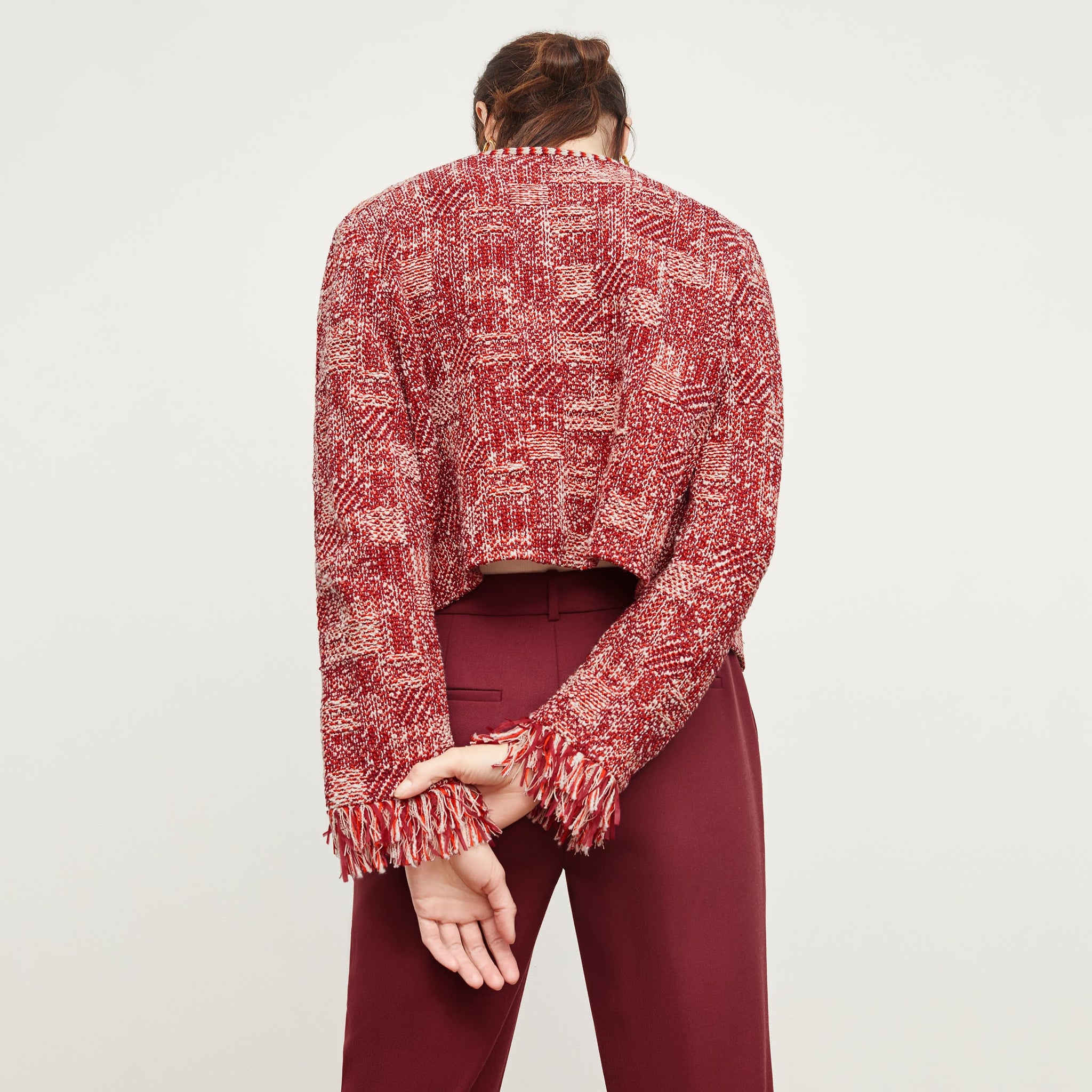 Back image of a woman standing wearing the Lilia Jacket—Interweave in Red Multi