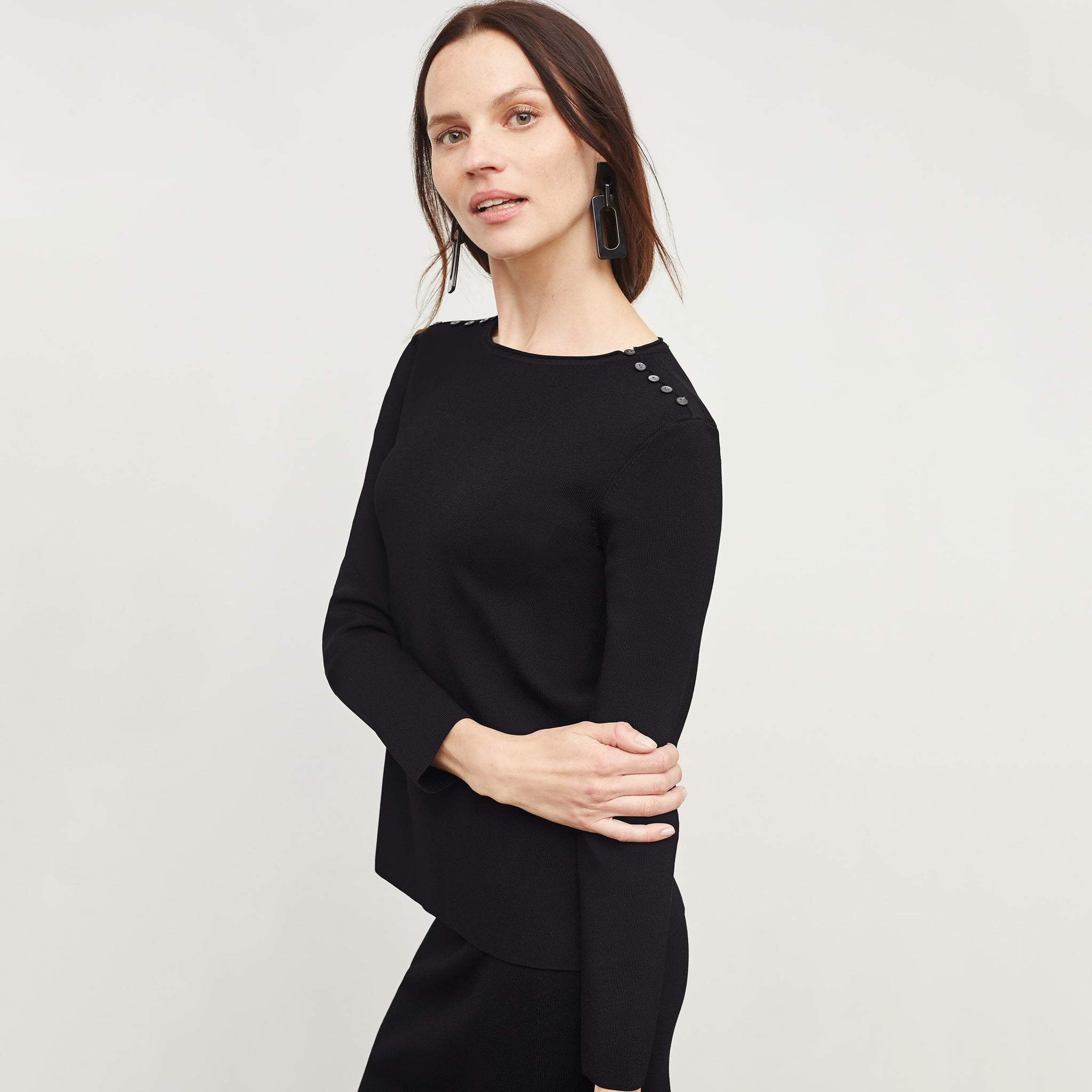 Side image of a woman standing wearing the Malin Top—Jardigan Knit in Black