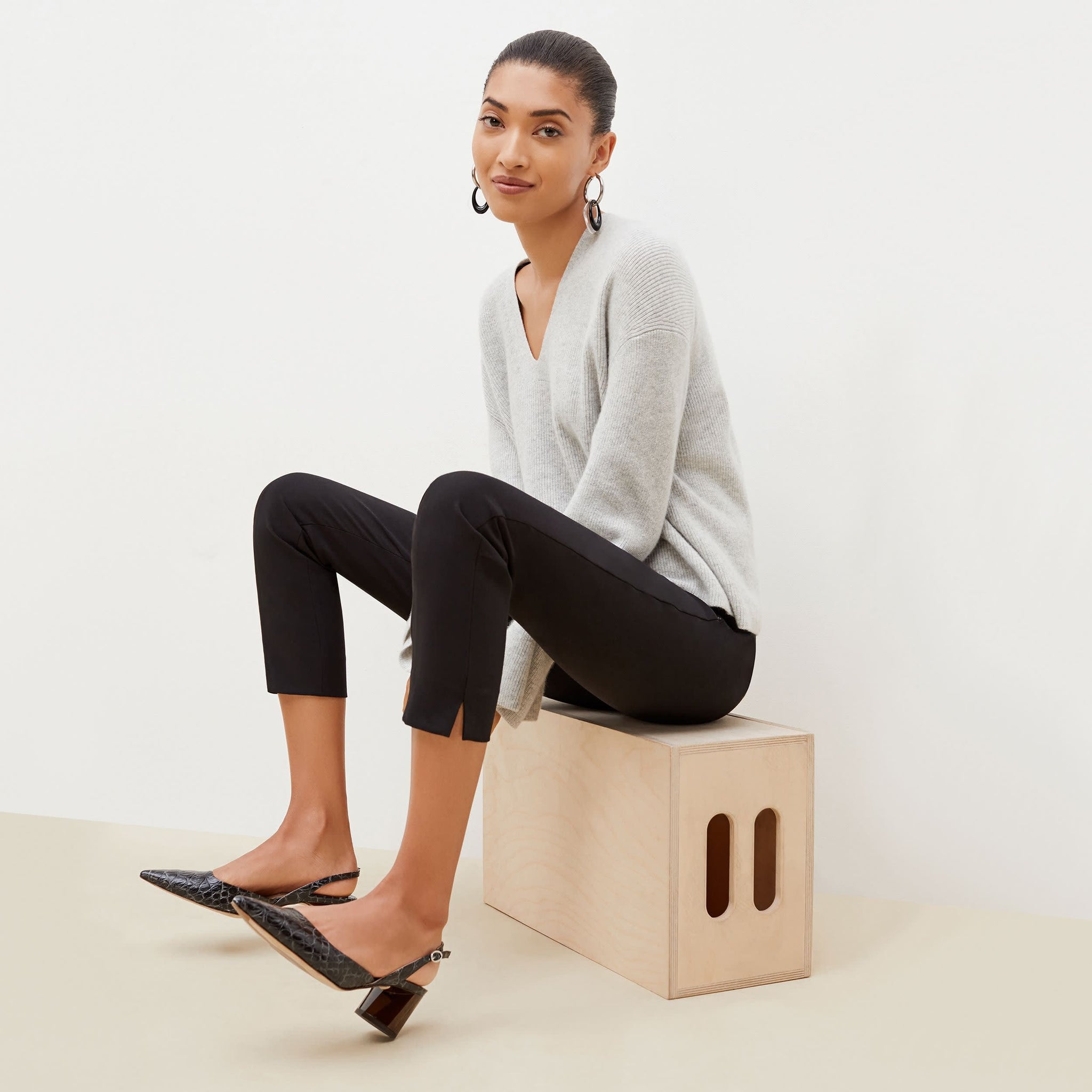 Side image of a woman sitting wearing the Marais pant in black
