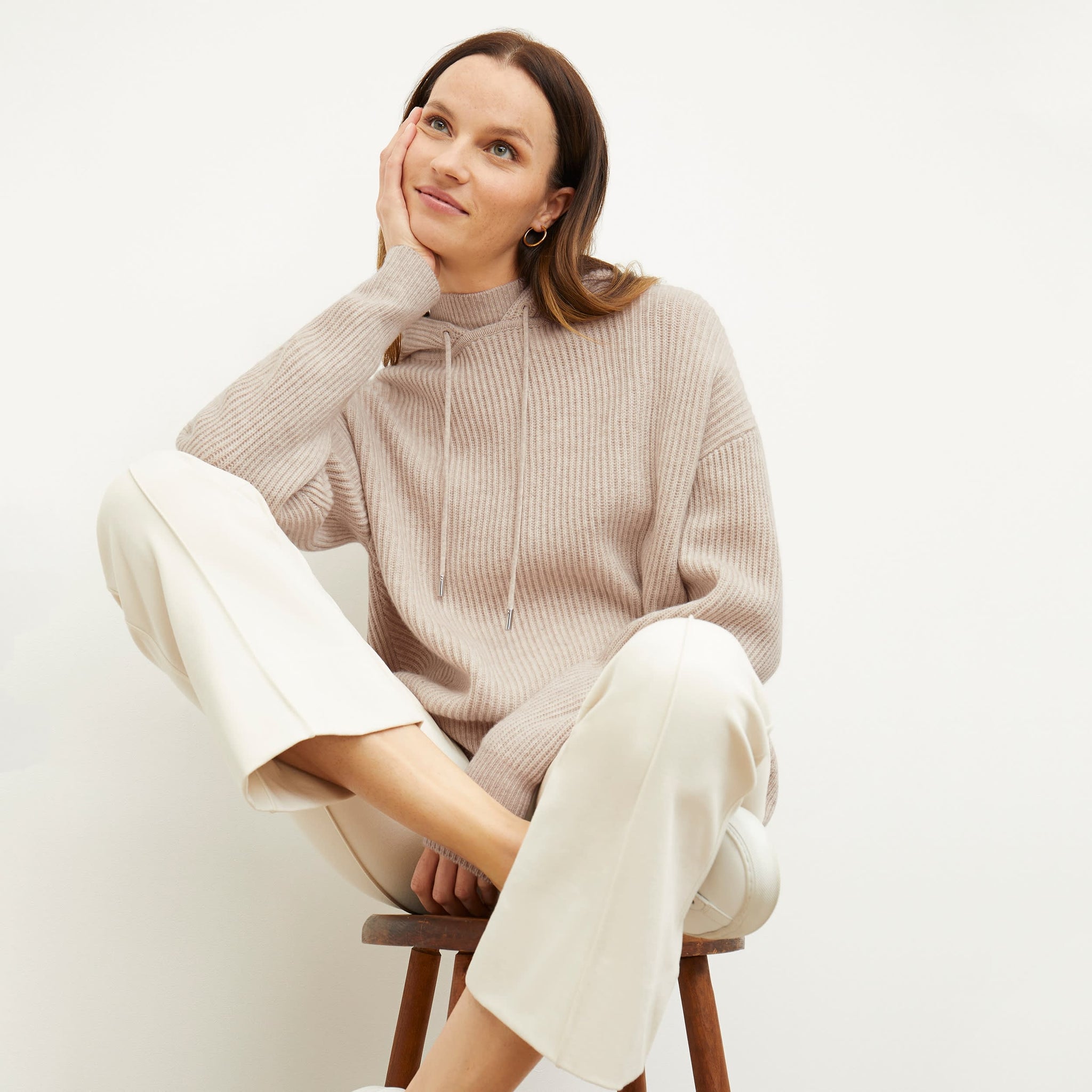 Front image of a woman standing wearing the Freya Hoodie—Cashmere/Wool in Oatmeal Melange 