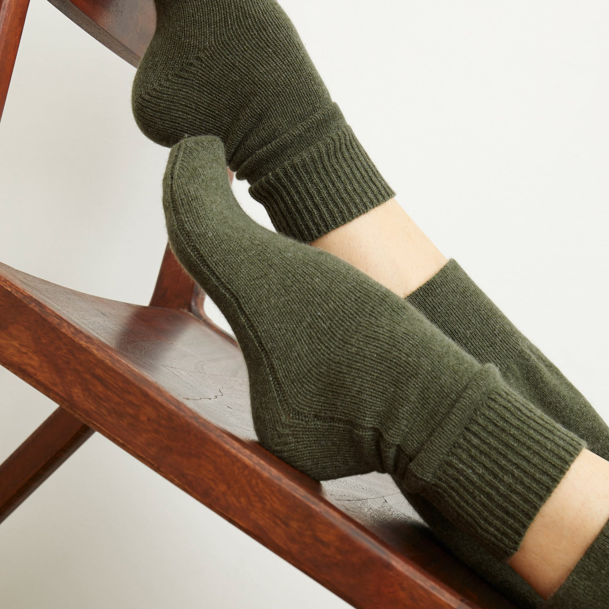 Front image of a woman wearing the ribbed cashmere socks in olive