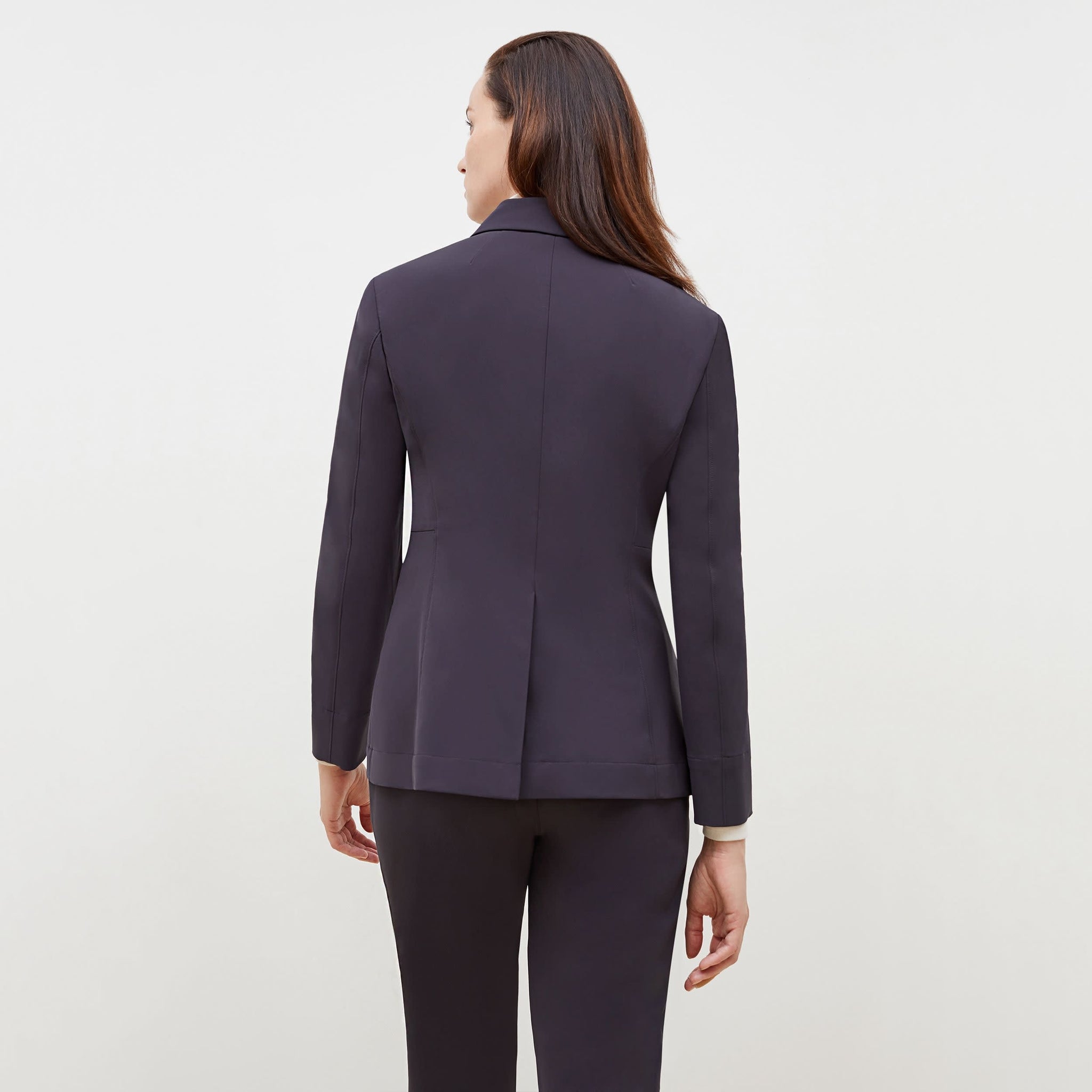 Back image of a woman standing wearing the Moreland Jacket—Origami Suiting in Cool Charcoal