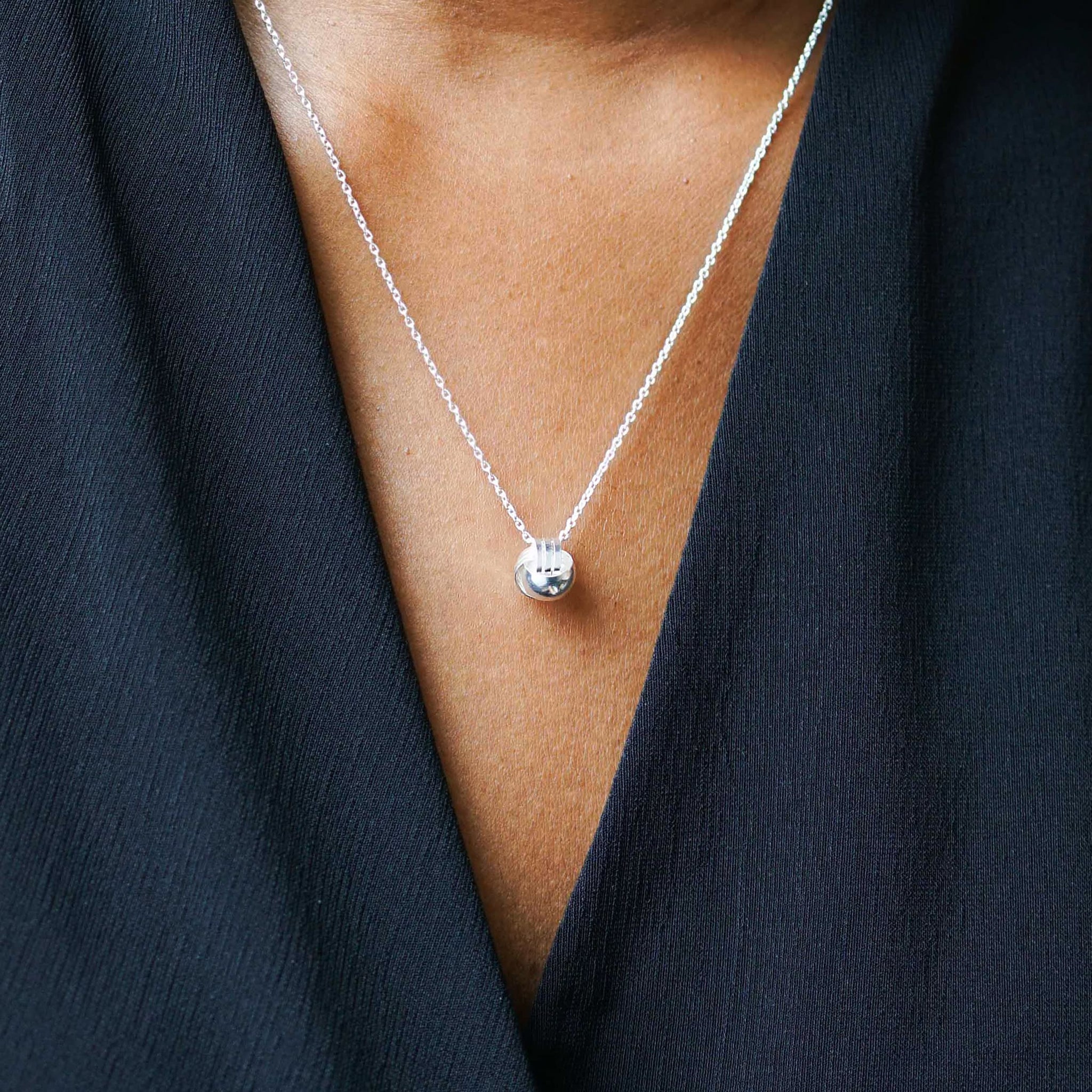 Front image of a woman standing wearing the Knot Necklace in Silver